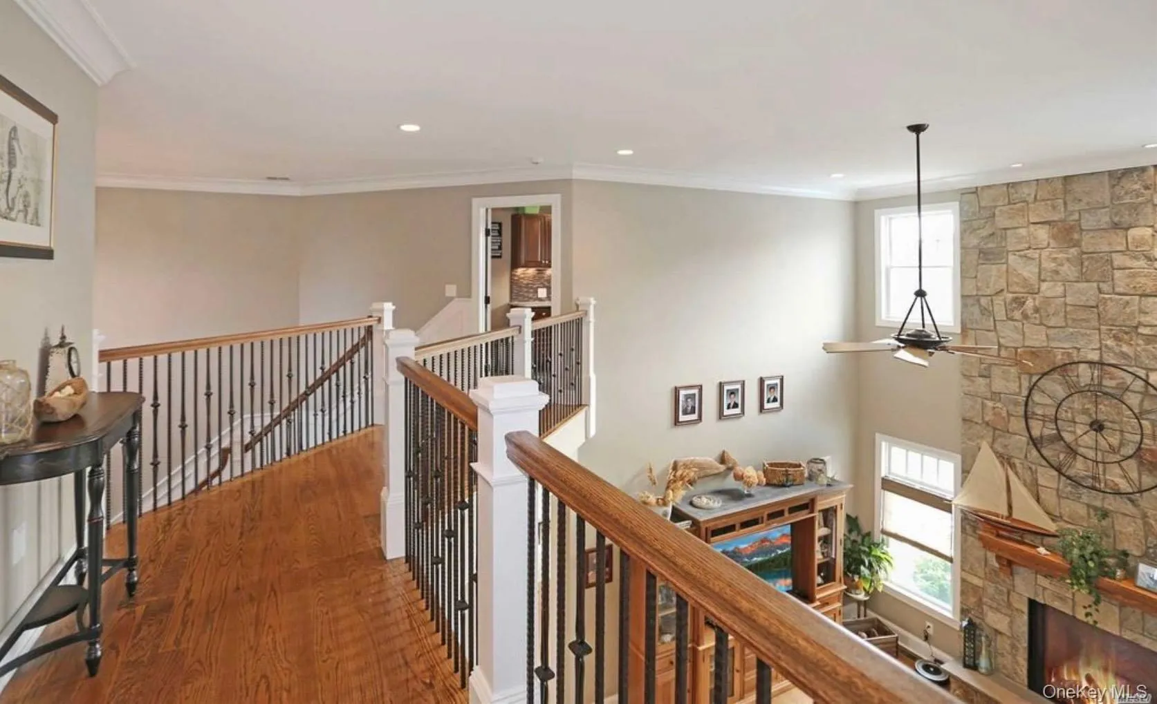 Corridor with ornamental molding, an upstairs landing, wood finished floors, and recessed lighting Corridor with ornamental molding, an upstairs landing, wood finished floors, and recessed lighting