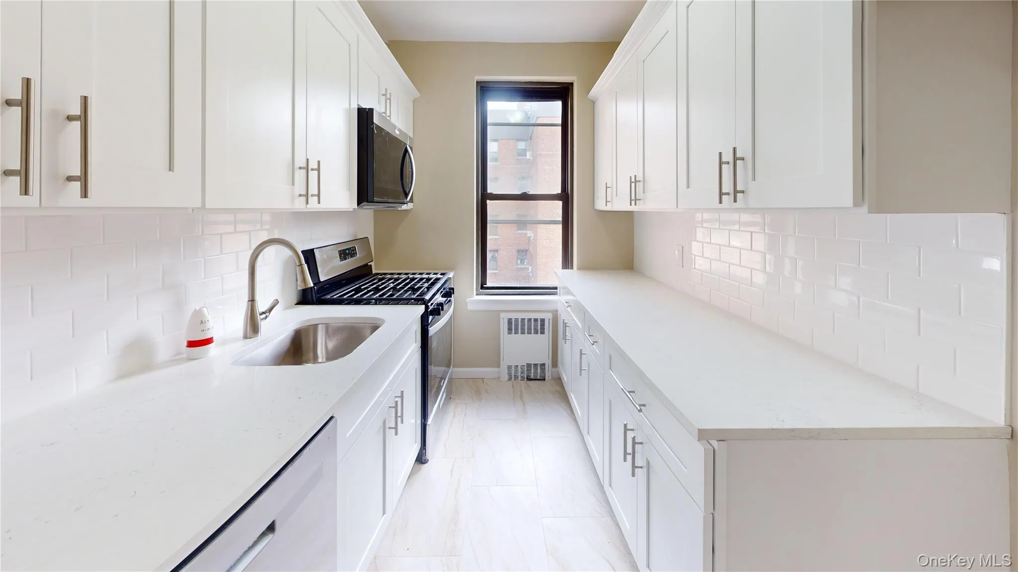 Kitchen featuring appliances with stainless steel finishes, backsplash, and white cabinets Kitchen featuring appliances with stainless steel finishes, backsplash, and white cabinets
