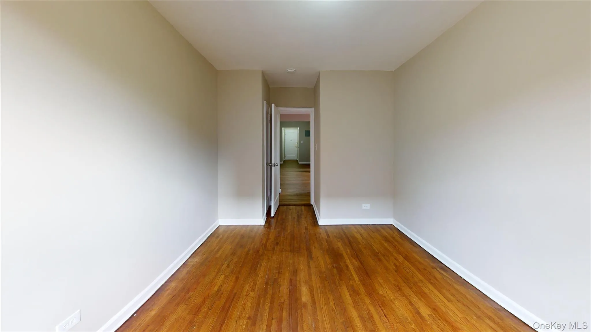Empty room with baseboards and dark wood finished floors Empty room with baseboards and dark wood finished floors