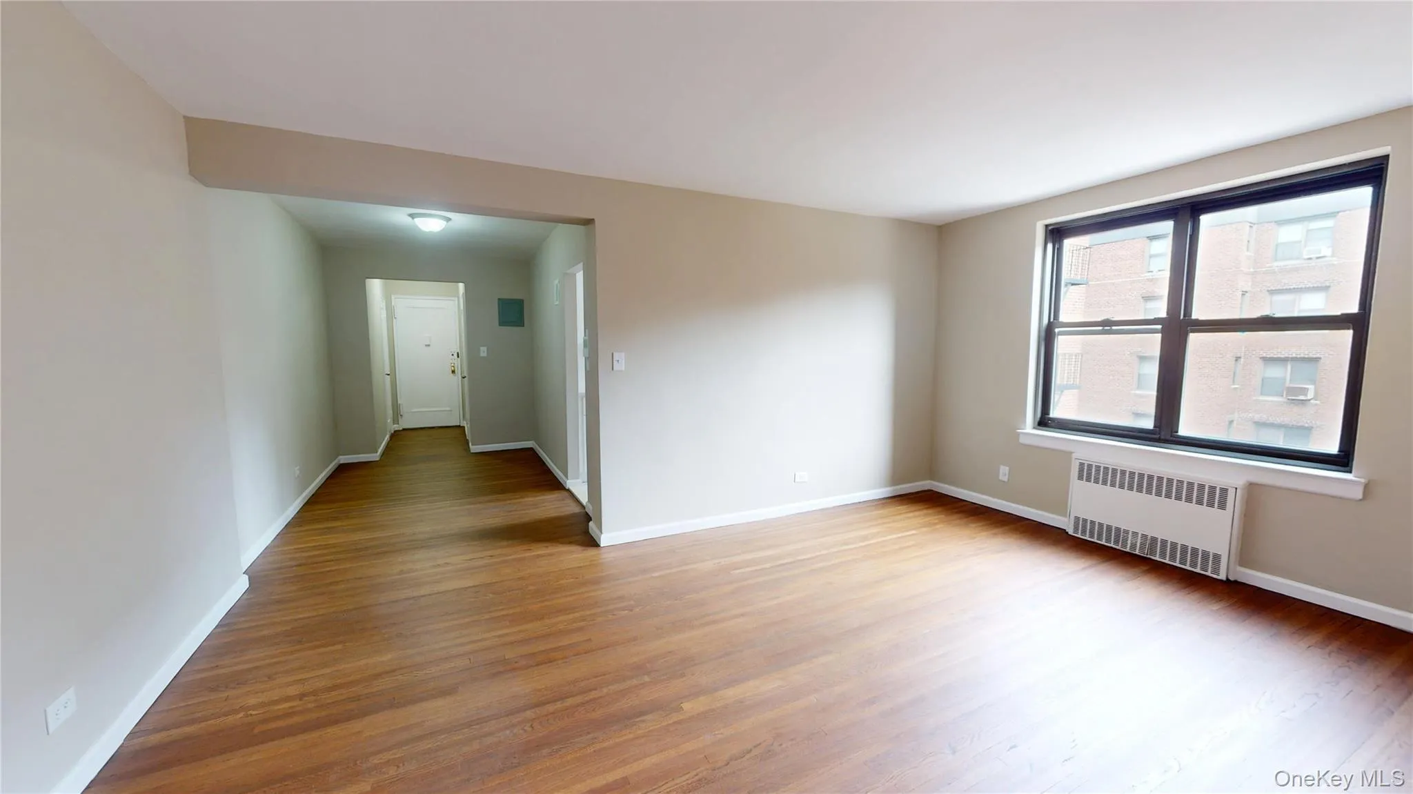 Empty room featuring radiator and light wood finished floors Empty room featuring radiator and light wood finished floors