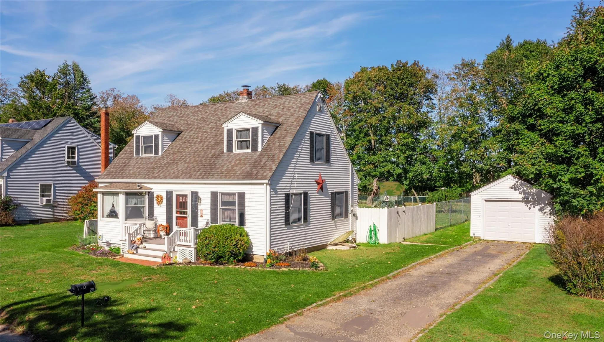 Cape cod home with a chimney, an outdoor structure, roof with shingles, and a garage Cape cod home with a chimney, an outdoor structure, roof with shingles, and a garage
