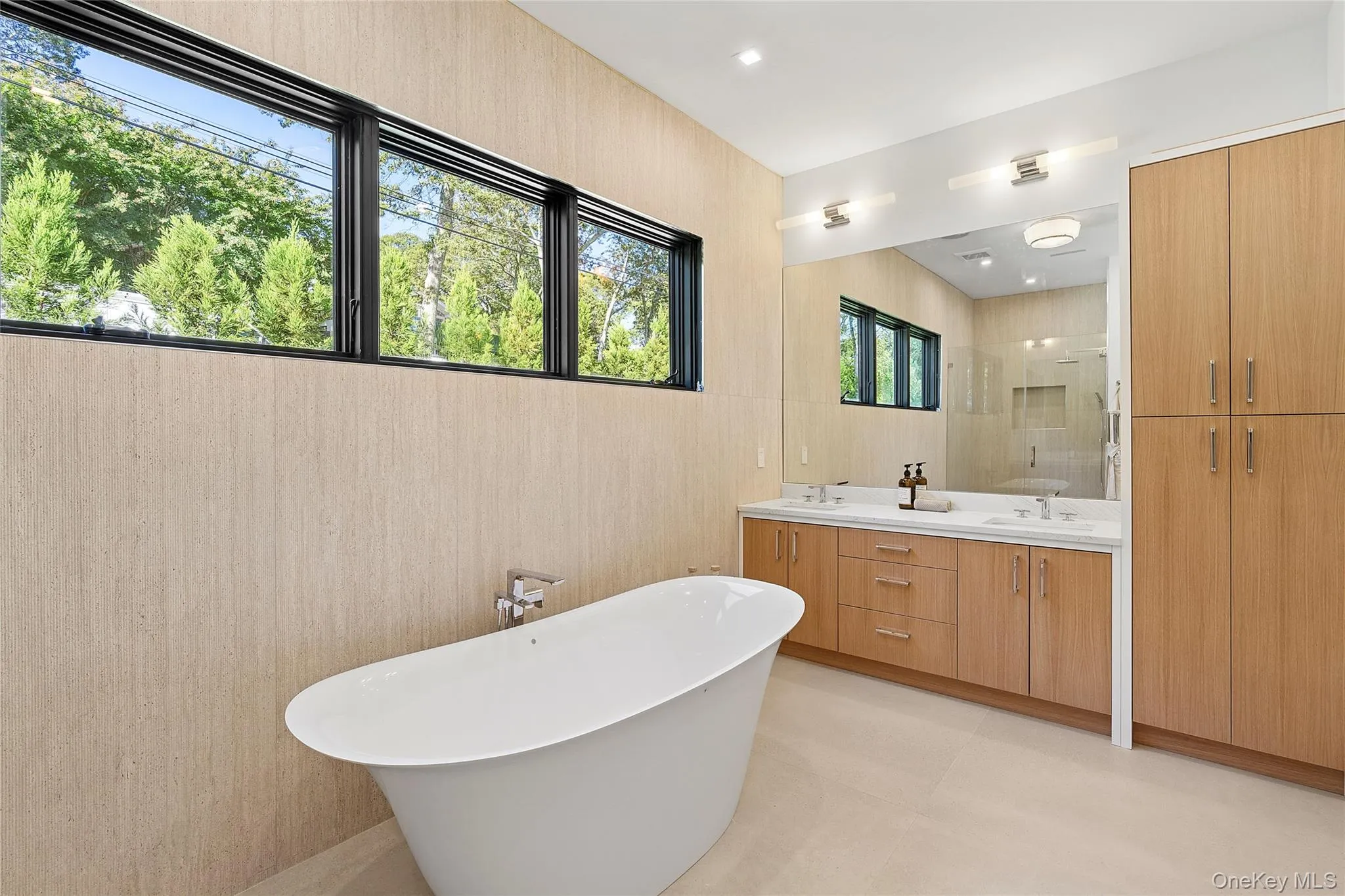 Full bath featuring double vanity, a freestanding tub, a shower stall, and recessed lighting Full bath featuring double vanity, a freestanding tub, a shower stall, and recessed lighting