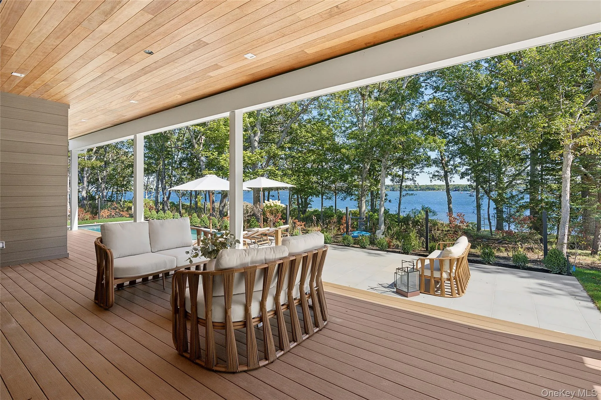 Wooden deck with a water view, outdoor lounge area, and a patio Wooden deck with a water view, outdoor lounge area, and a patio