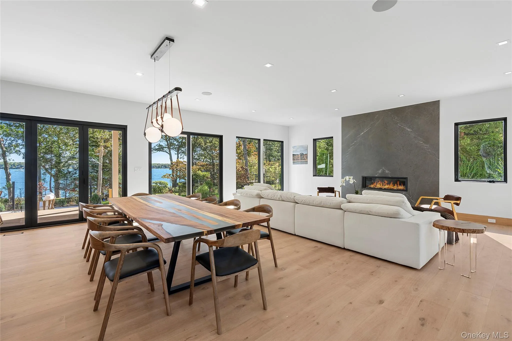 Dining space with light wood-type flooring, a premium fireplace, plenty of natural light, and recessed lighting Dining space with light wood-type flooring, a premium fireplace, plenty of natural light, and recessed lighting