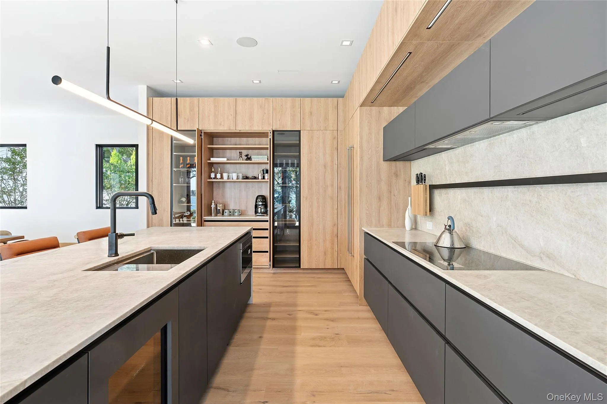 Kitchen with decorative light fixtures, open shelves, gray cabinetry, light wood-style floors, and dark cabinets Kitchen with decorative light fixtures, open shelves, gray cabinetry, light wood-style floors, and dark cabinets