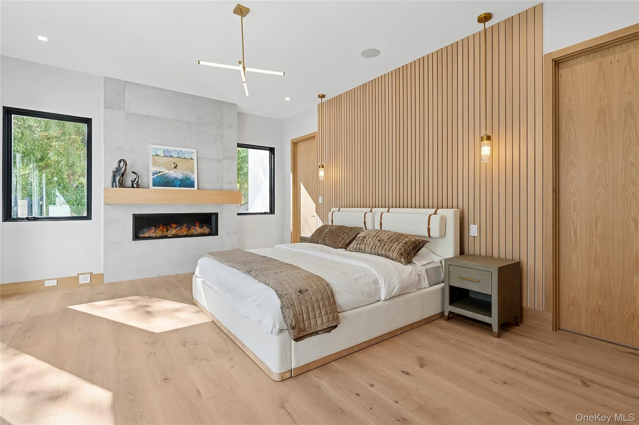 Bedroom with a tiled fireplace and light wood-style floors Bedroom with a tiled fireplace and light wood-style floors