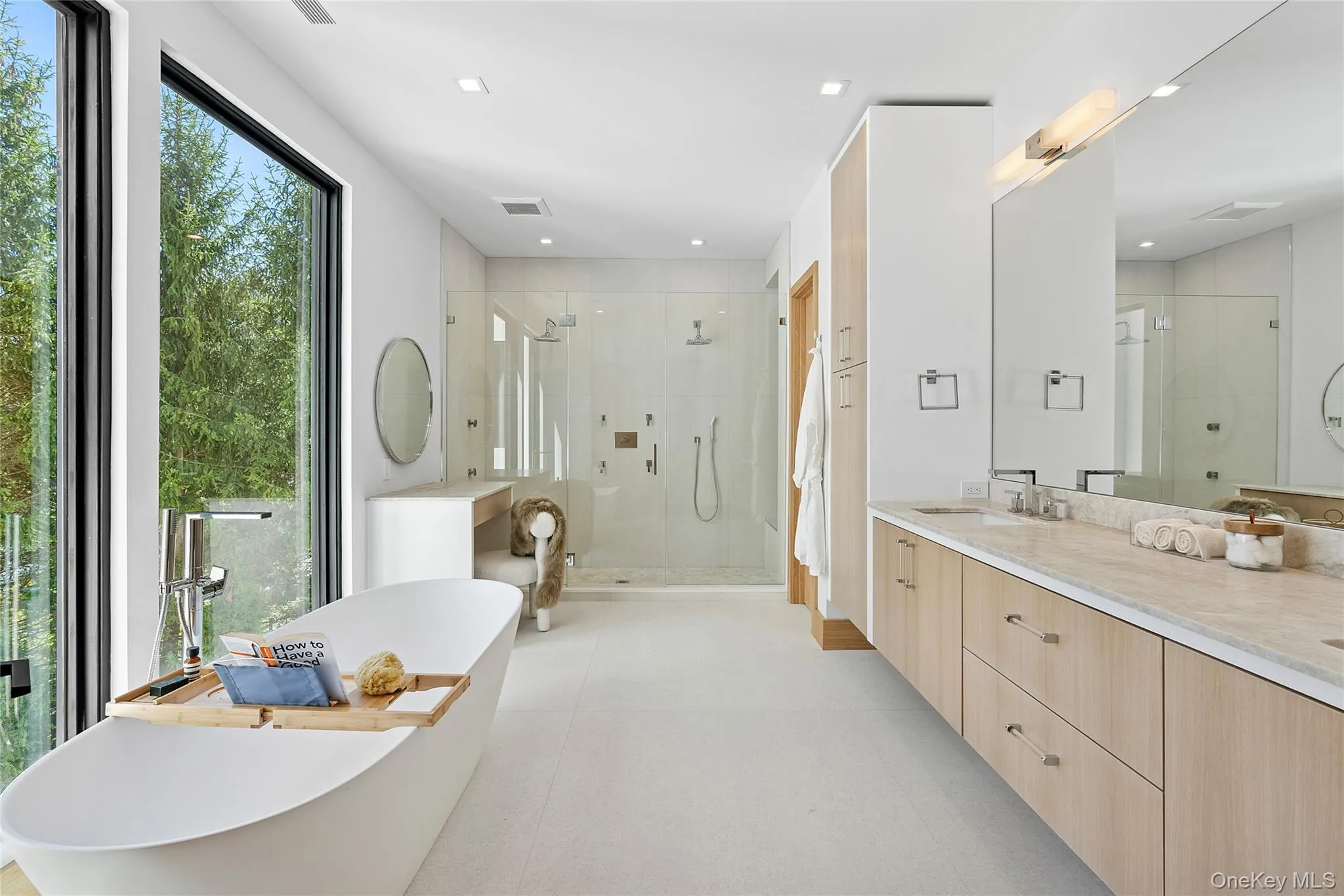 Bathroom with double vanity, a stall shower, and a freestanding bath