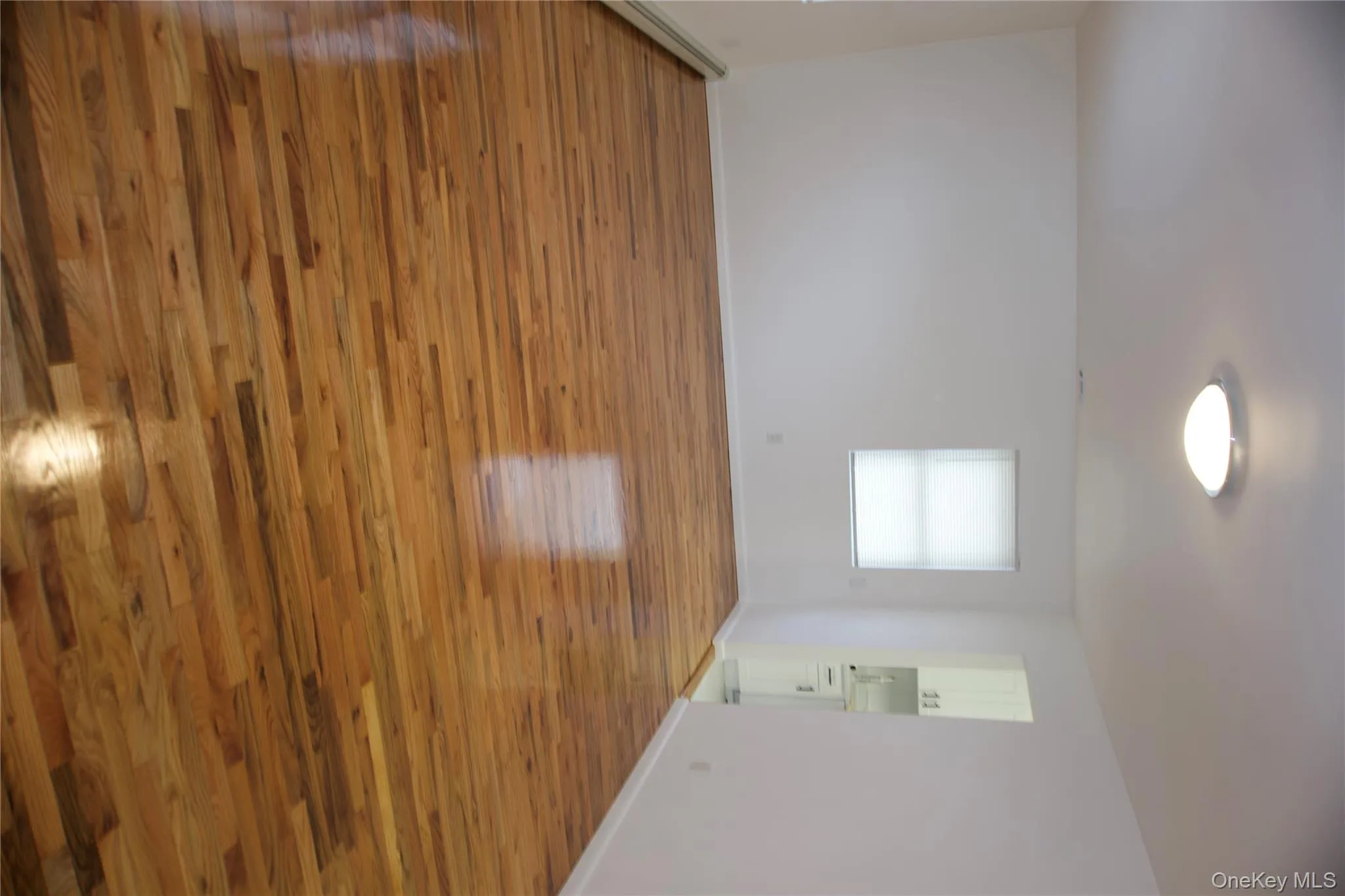 Unfurnished room with light wood-type flooring and a baseboard radiator Unfurnished room with light wood-type flooring and a baseboard radiator