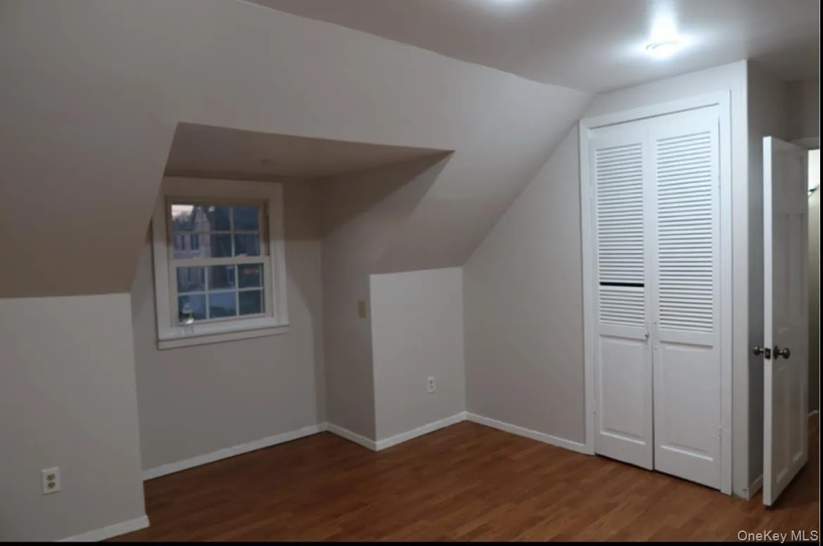 Additional living space with lofted ceiling and dark wood-type flooring Additional living space with lofted ceiling and dark wood-type flooring