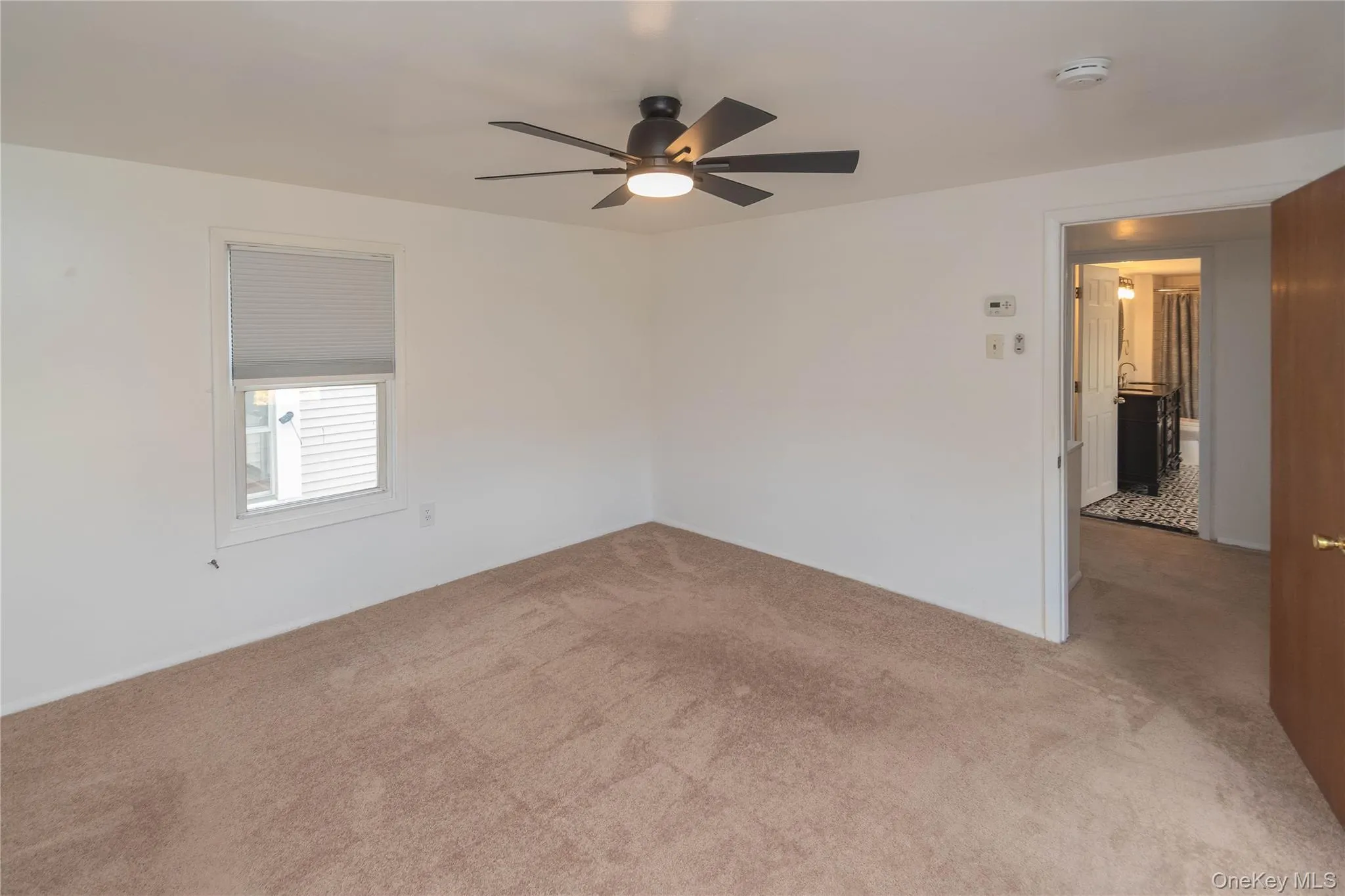Spare room with light colored carpet and a ceiling fan Spare room with light colored carpet and a ceiling fan