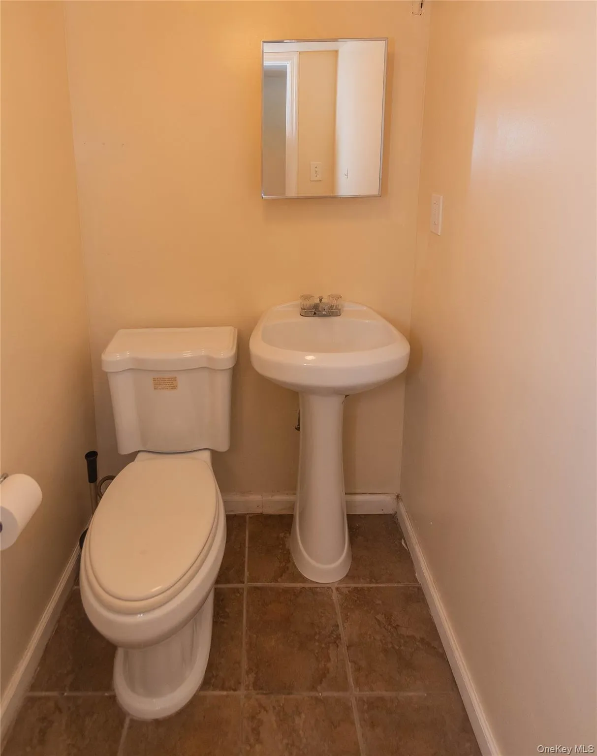Bathroom featuring toilet and dark tile patterned flooring Bathroom featuring toilet and dark tile patterned flooring
