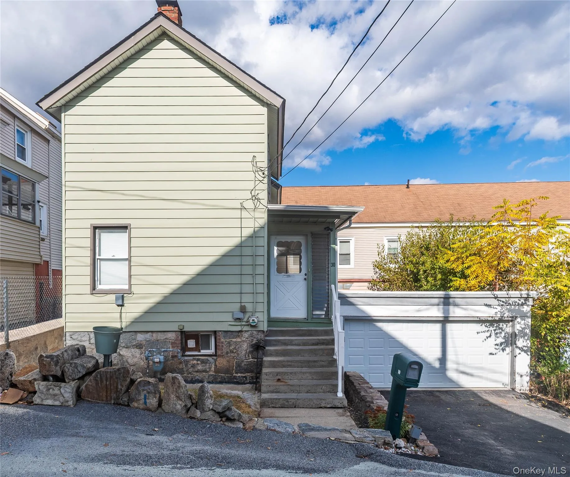 View of front of home featuring a chimney and driveway View of front of home featuring a chimney and driveway