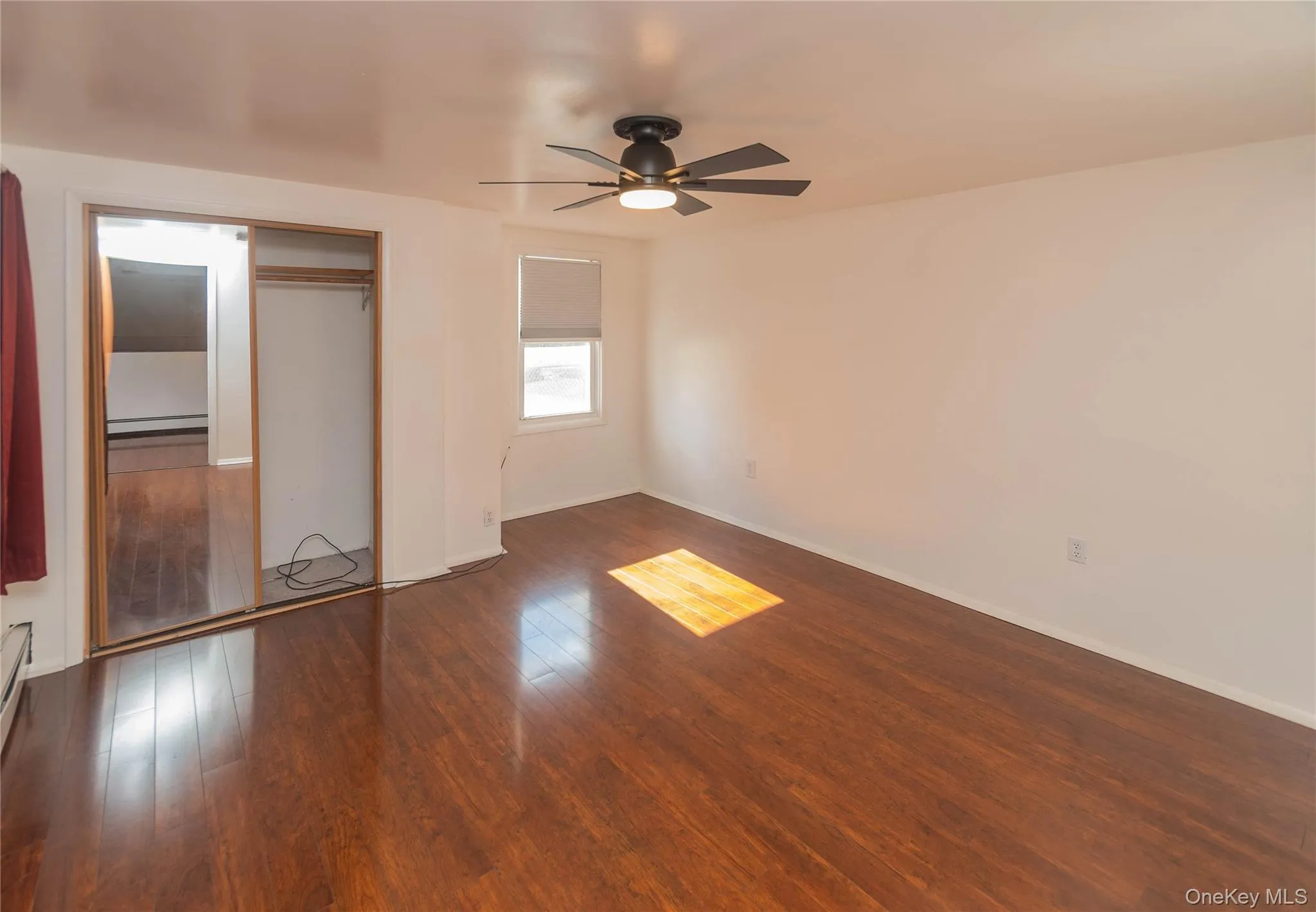 Unfurnished bedroom with dark wood-style floors, a ceiling fan, and a closet Unfurnished bedroom with dark wood-style floors, a ceiling fan, and a closet