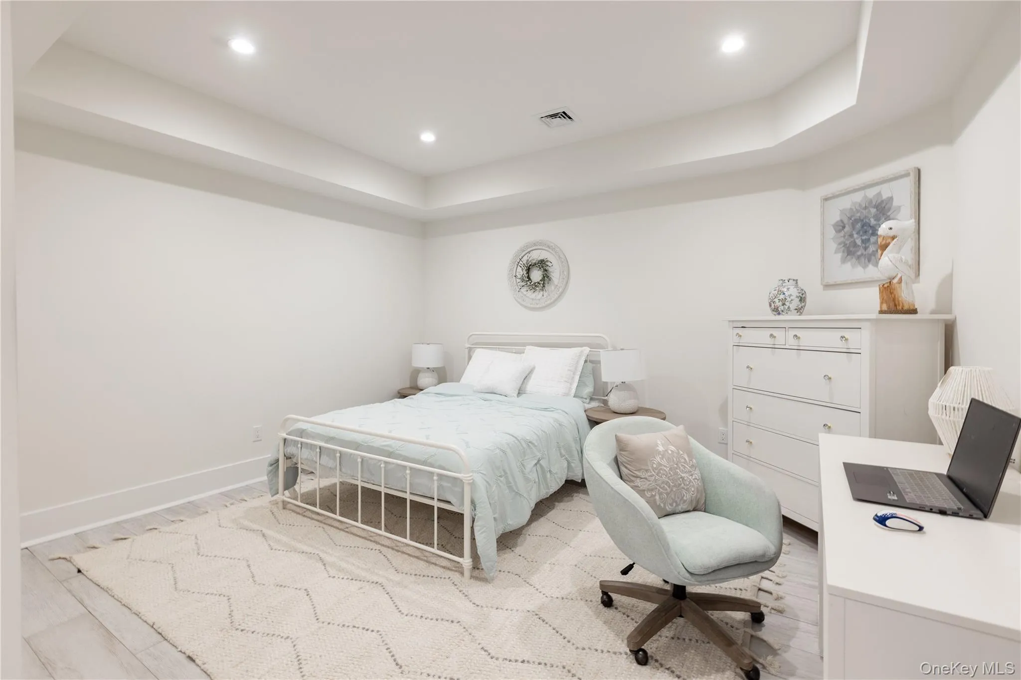 Bedroom with a raised ceiling, wood finished floors, and recessed lighting Bedroom with a raised ceiling, wood finished floors, and recessed lighting
