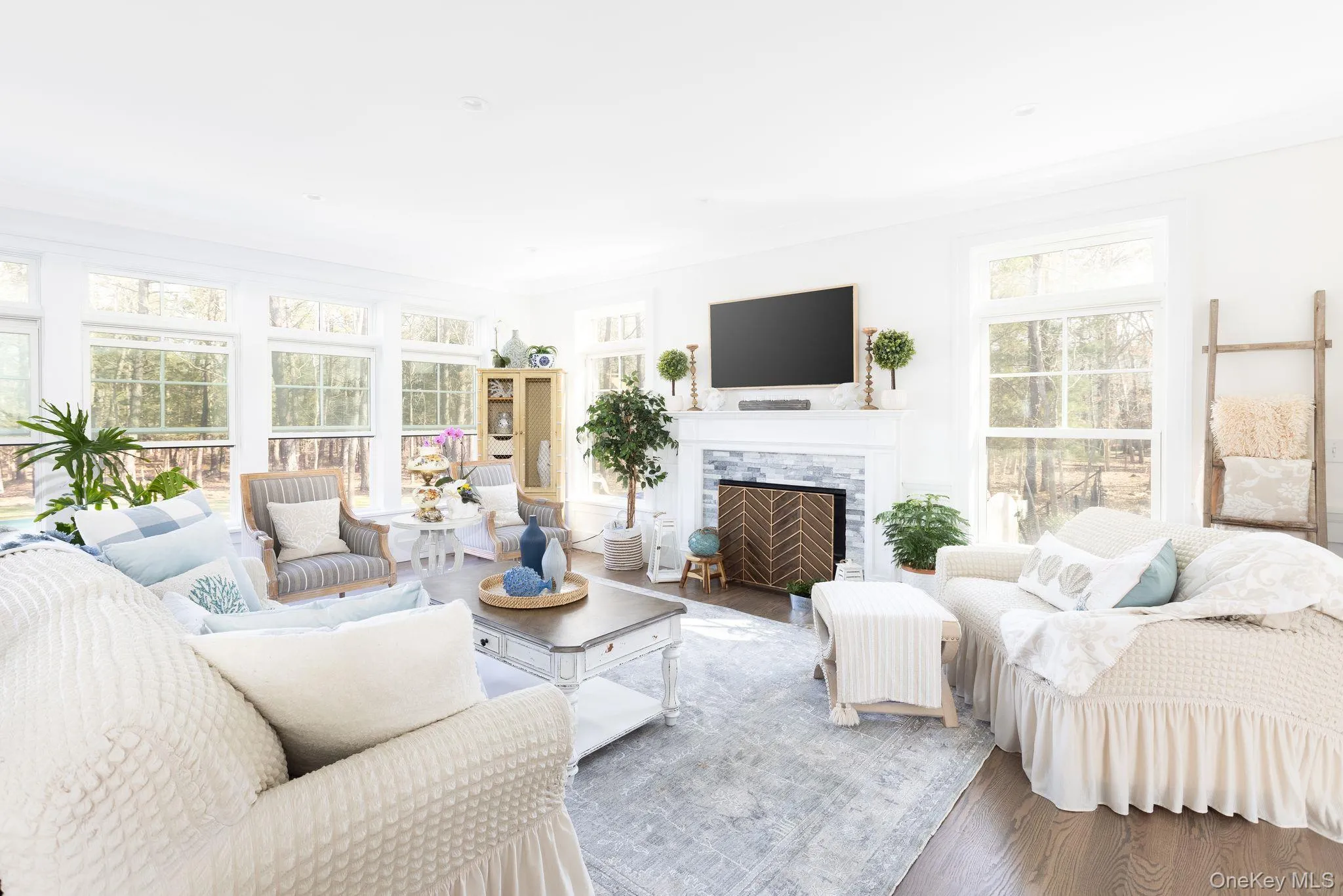 Living area featuring plenty of natural light, wood finished floors, and ornamental molding Living area featuring plenty of natural light, wood finished floors, and ornamental molding