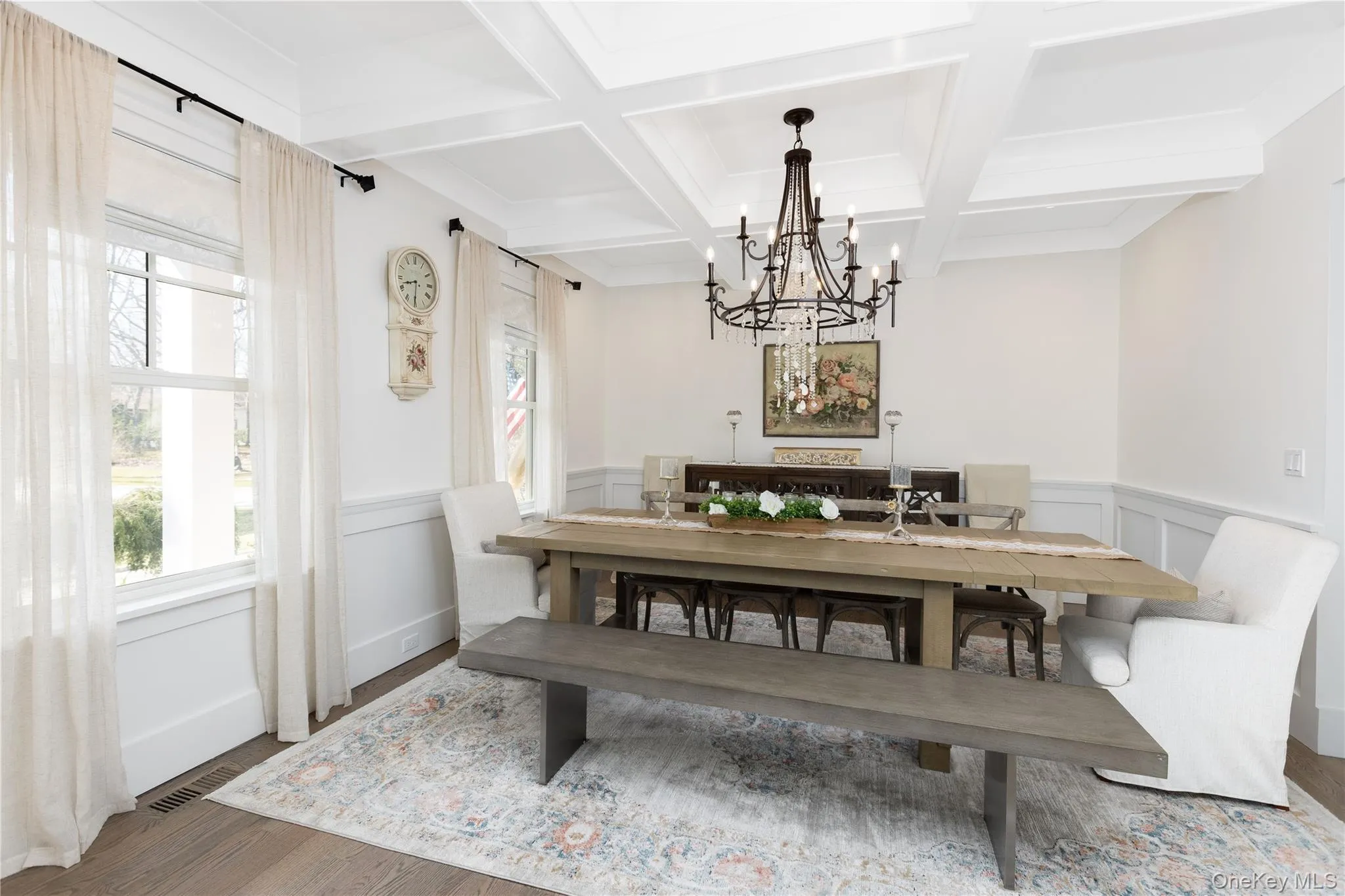 Dining space with beam ceiling, wood finished floors, coffered ceiling, a chandelier, and wainscoting Dining space with beam ceiling, wood finished floors, coffered ceiling, a chandelier, and wainscoting