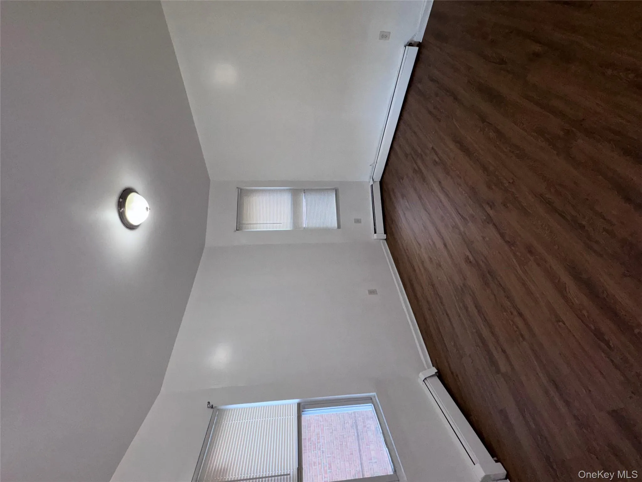 Empty room with baseboard heating and dark wood-style flooring Empty room with baseboard heating and dark wood-style flooring