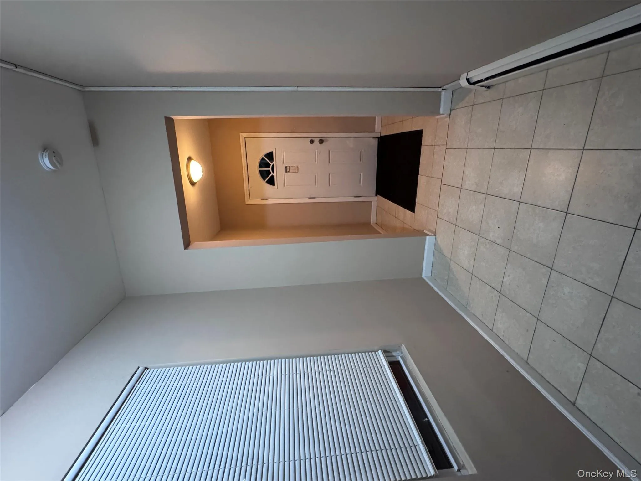 Doorway to outside featuring baseboard heating and tile patterned flooring Doorway to outside featuring baseboard heating and tile patterned flooring