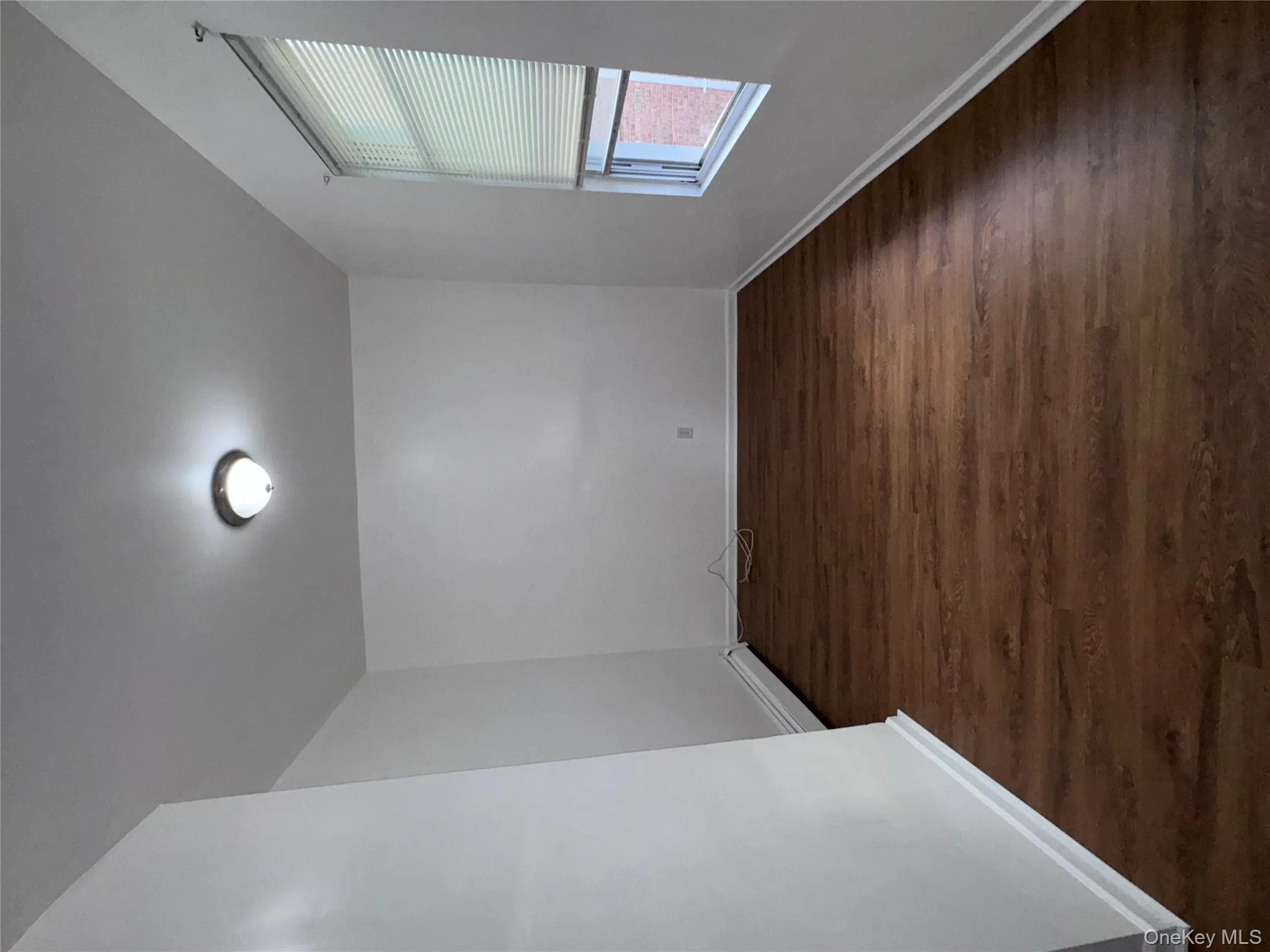 Spare room with dark wood-style flooring and a baseboard radiator Spare room with dark wood-style flooring and a baseboard radiator