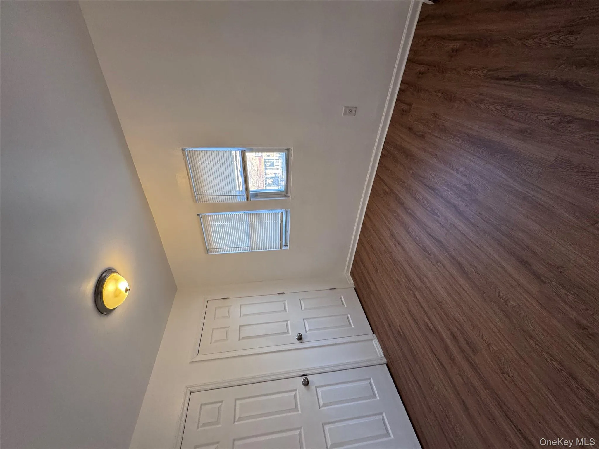 Unfurnished bedroom featuring dark wood-type flooring and two closets Unfurnished bedroom featuring dark wood-type flooring and two closets