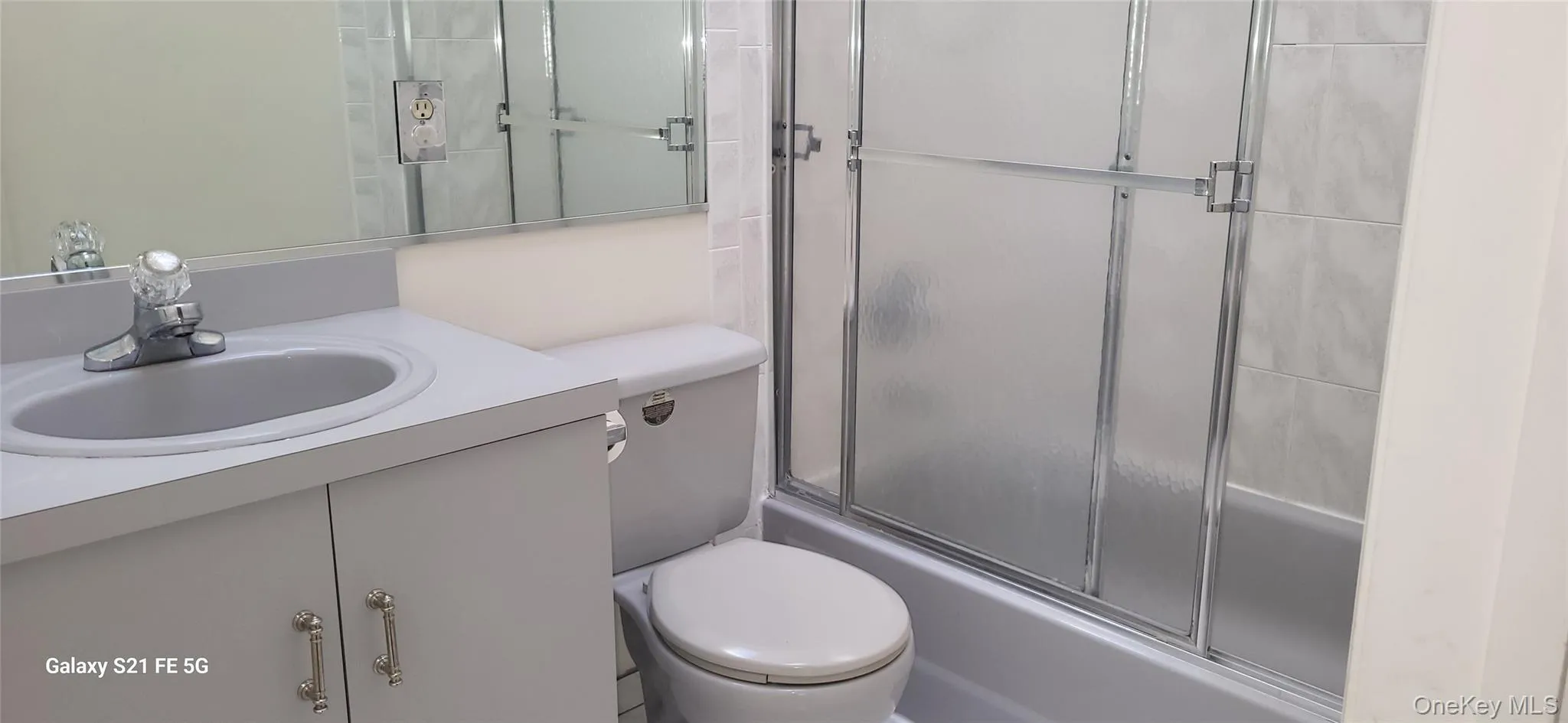 Bathroom with vanity and bath / shower combo with glass door Bathroom with vanity and bath / shower combo with glass door