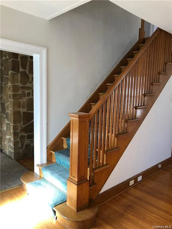 Stairs featuring wood finished floors and baseboards Stairs featuring wood finished floors and baseboards