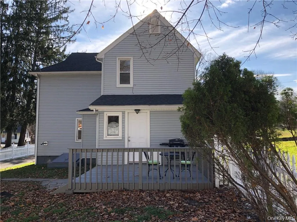 Rear view of property with a deck and a shingled roof Rear view of property with a deck and a shingled roof