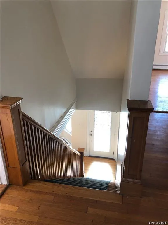 Stairway with wood-type flooring and a high ceiling Stairway with wood-type flooring and a high ceiling