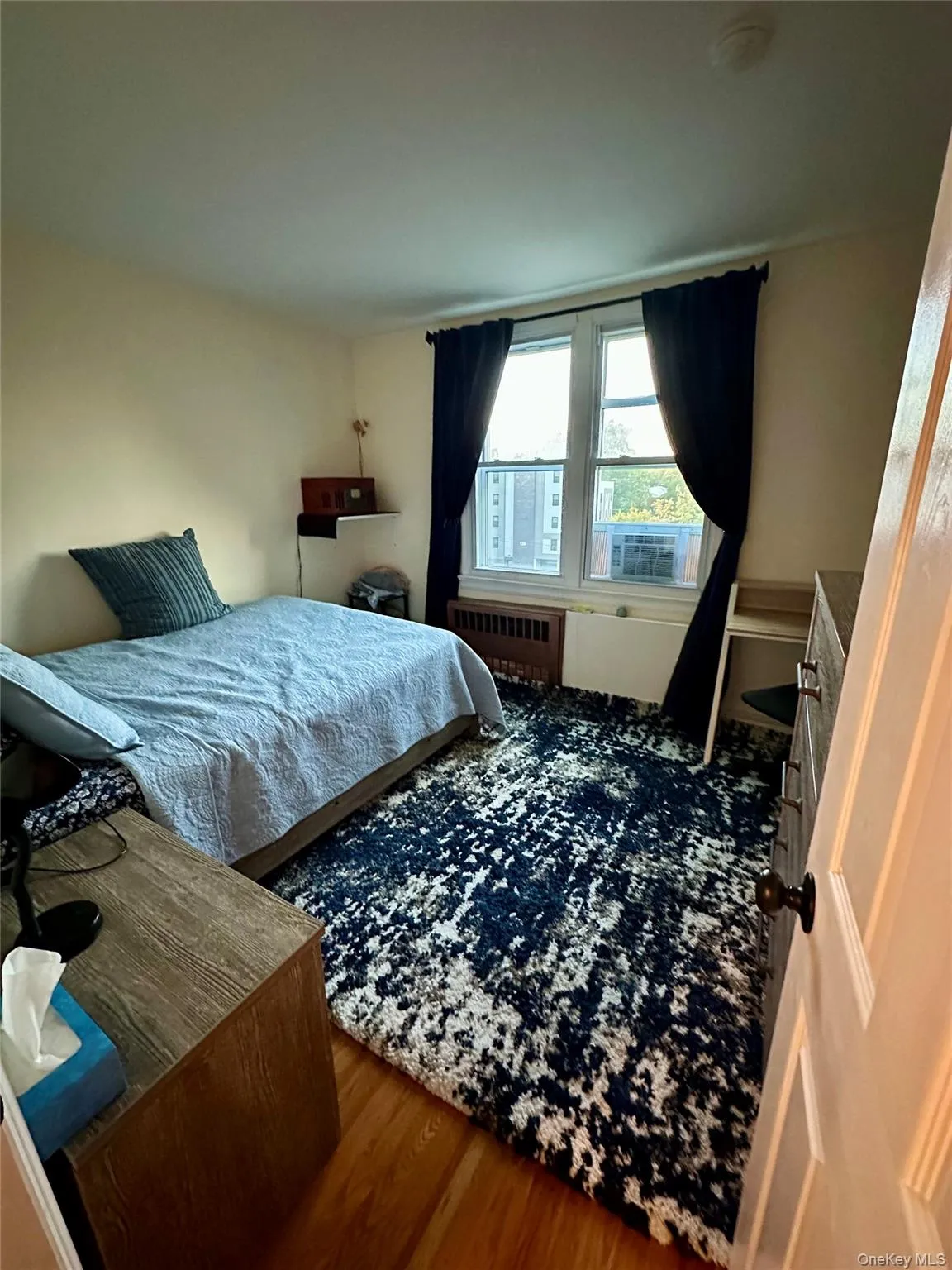 Bedroom featuring wood finished floors and radiator Bedroom featuring wood finished floors and radiator