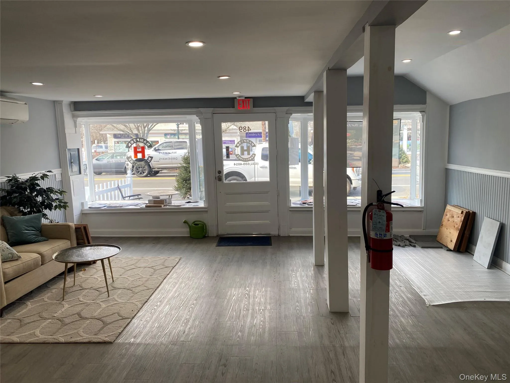 Foyer entrance with wood finished floors, wainscoting, lofted ceiling, recessed lighting, and a wall mounted air conditioner Foyer entrance with wood finished floors, wainscoting, lofted ceiling, recessed lighting, and a wall mounted air conditioner