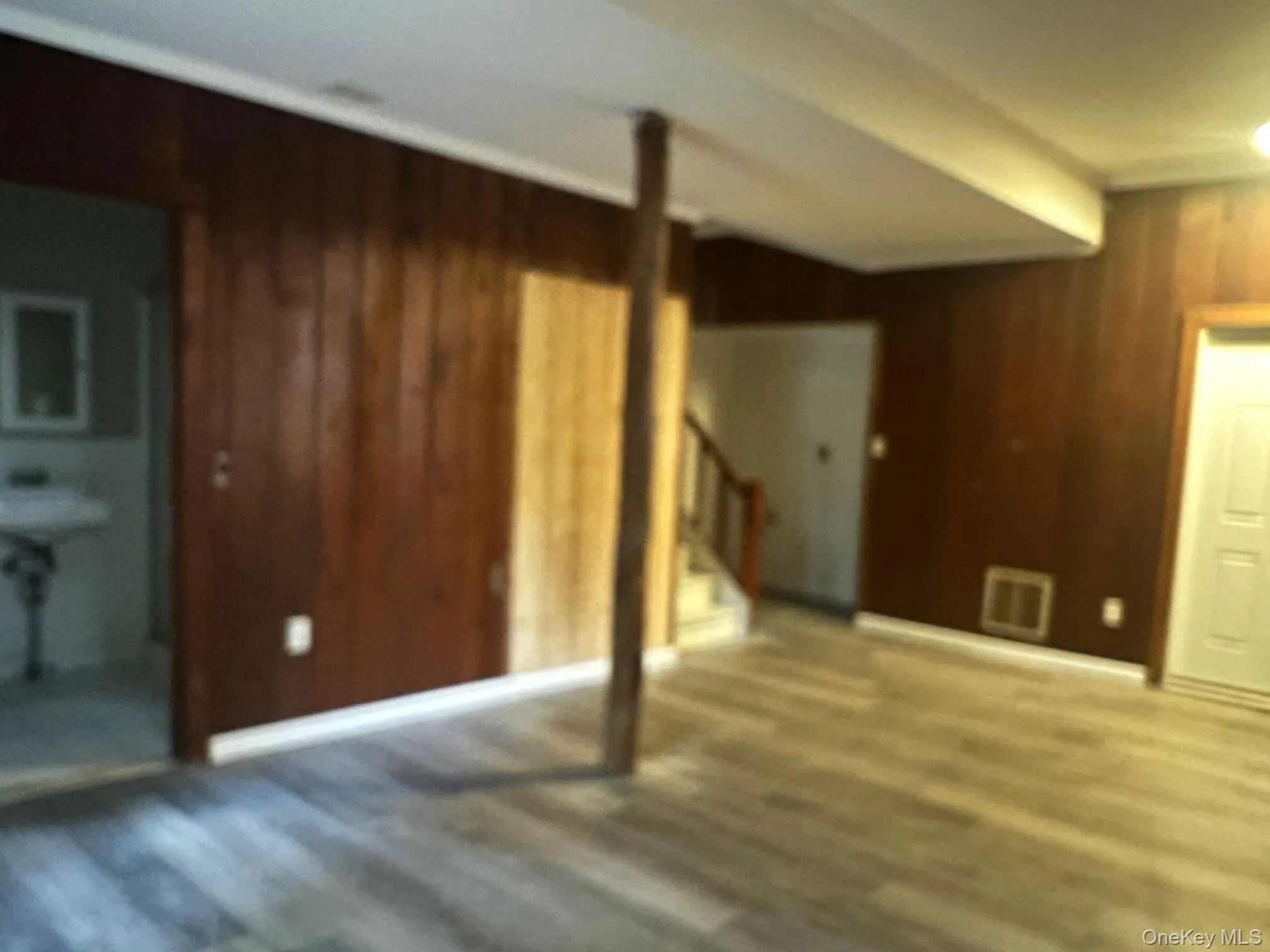 Basement featuring wood walls and wood finished floors Basement featuring wood walls and wood finished floors