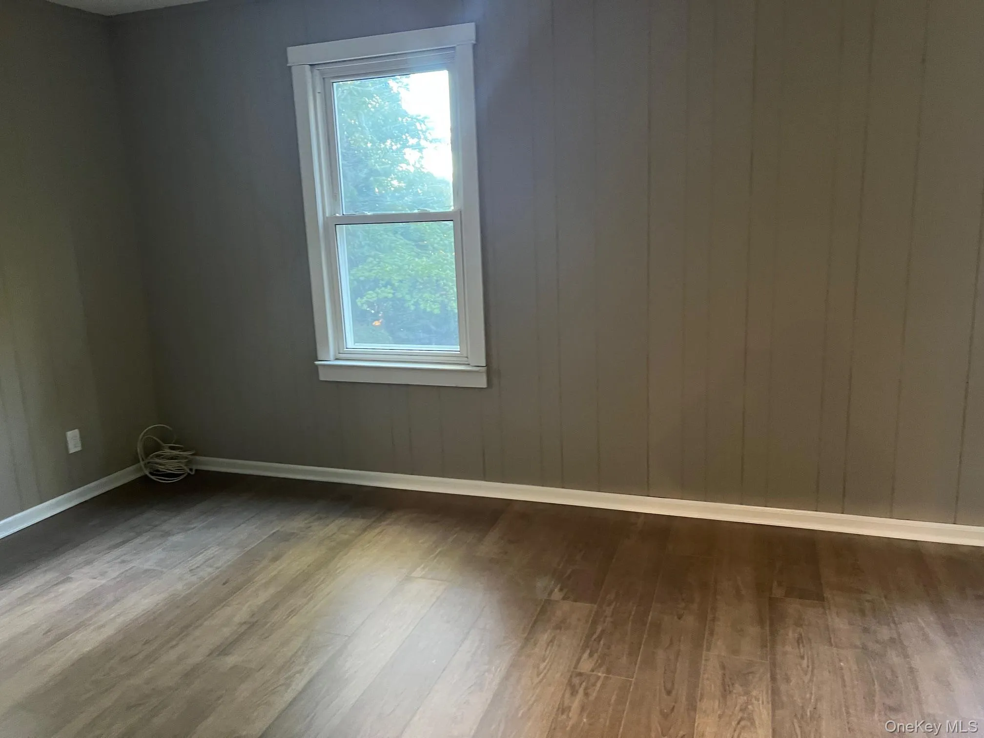 Spare room with wood finished floors and baseboards Spare room with wood finished floors and baseboards