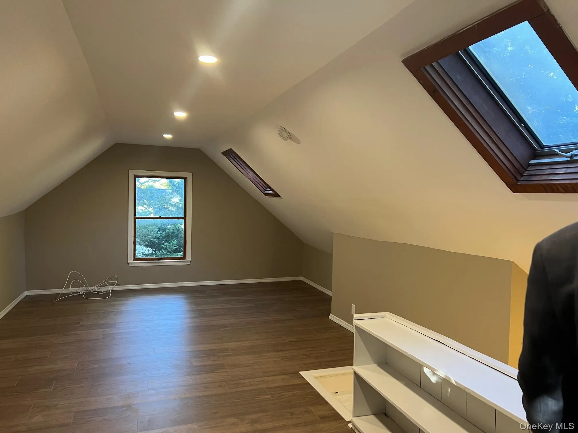 Bonus room with a skylight, dark wood finished floors, vaulted ceiling, and recessed lighting Bonus room with a skylight, dark wood finished floors, vaulted ceiling, and recessed lighting