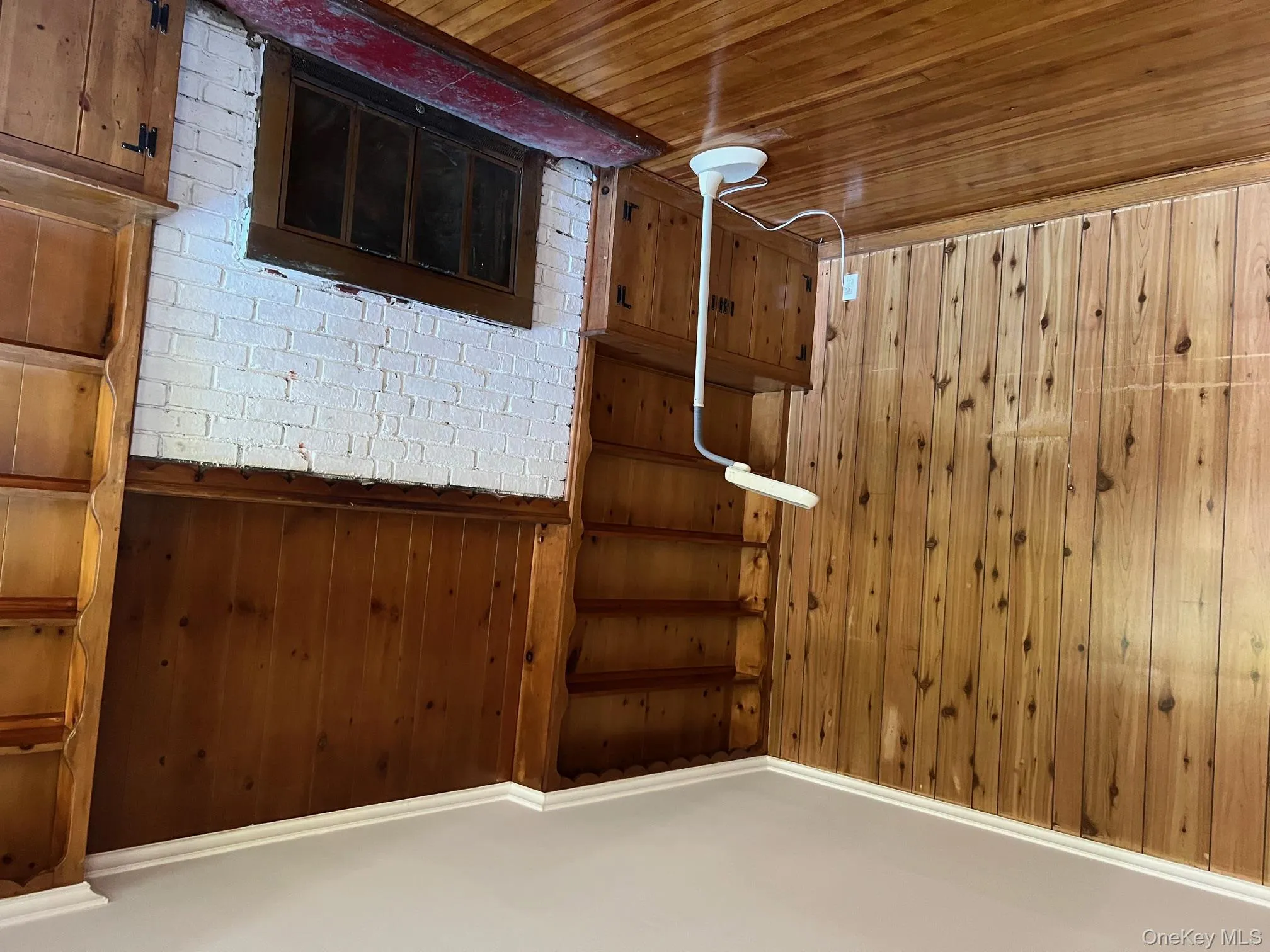 Unfurnished living room with wood walls, hardwood / wood-style flooring, and a fireplace Unfurnished living room with wood walls, hardwood / wood-style flooring, and a fireplace