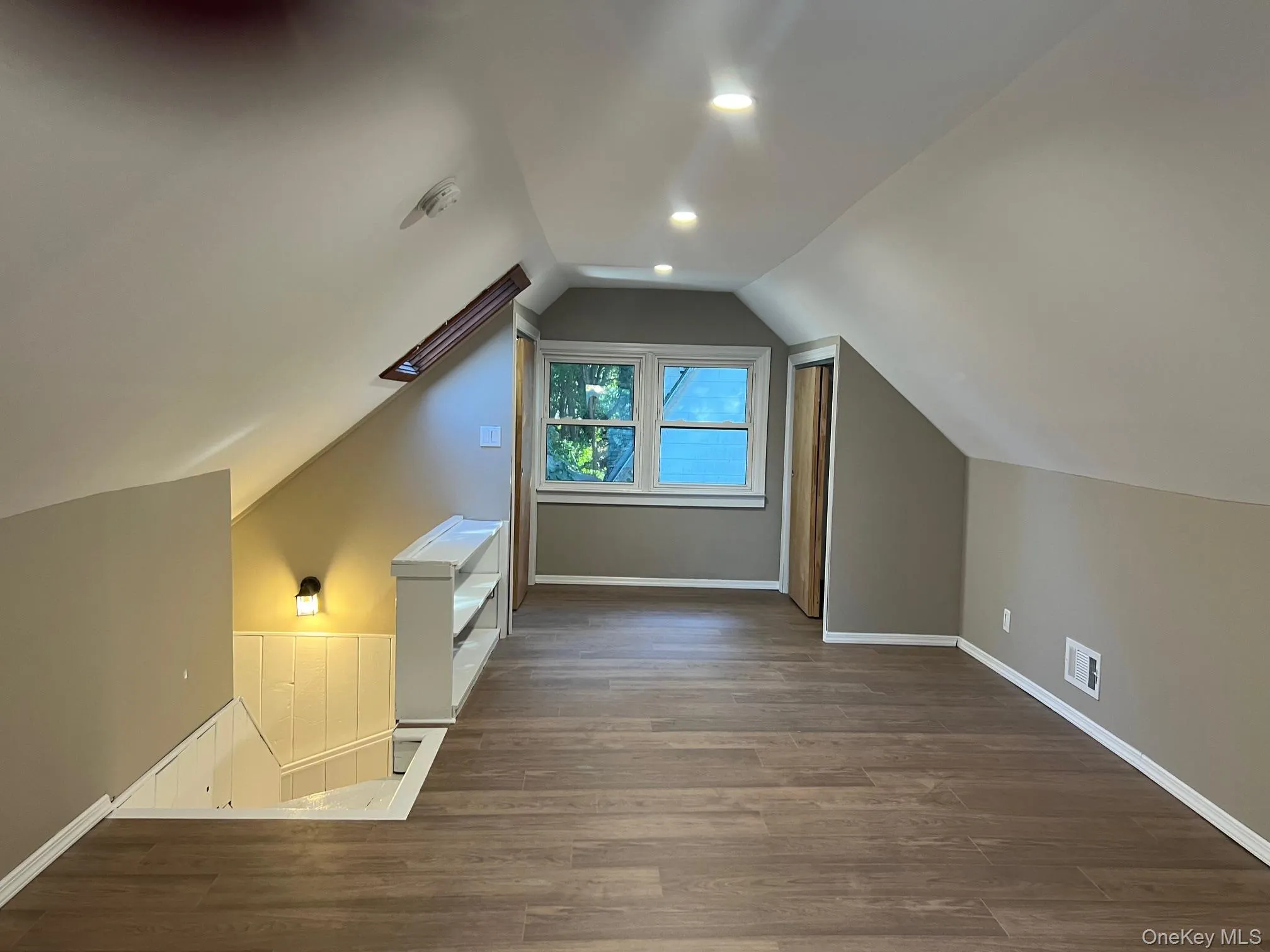 Additional living space with wood finished floors, lofted ceiling, a skylight, and recessed lighting Additional living space with wood finished floors, lofted ceiling, a skylight, and recessed lighting