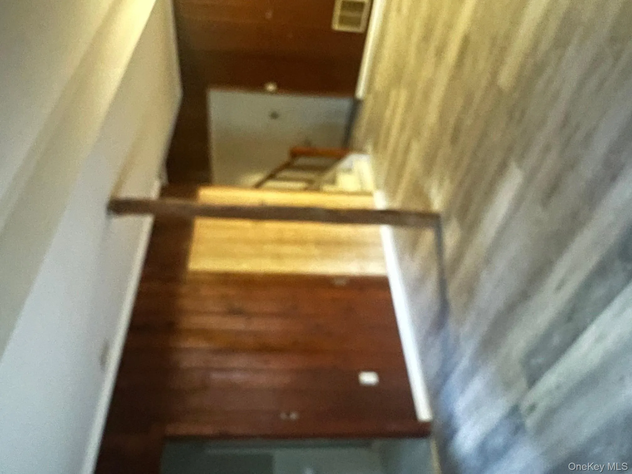 Unfurnished living room featuring wooden walls and wood finished floors Unfurnished living room featuring wooden walls and wood finished floors