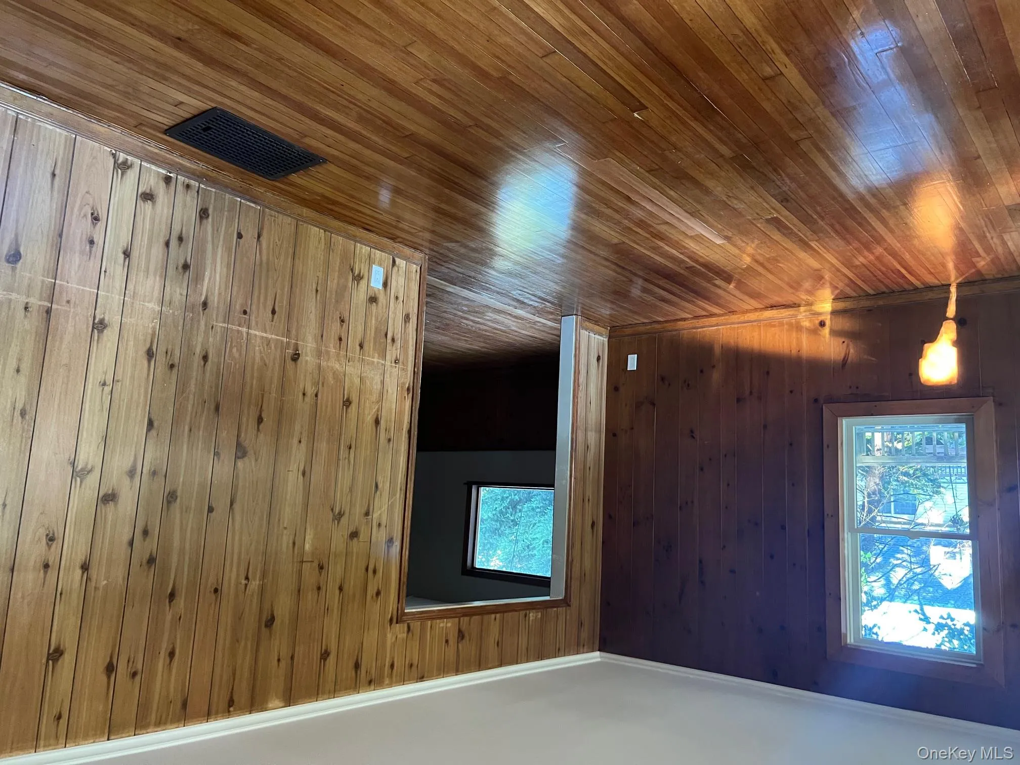 Unfurnished room with wood walls, hardwood / wood-style flooring, and crown molding Unfurnished room with wood walls, hardwood / wood-style flooring, and crown molding