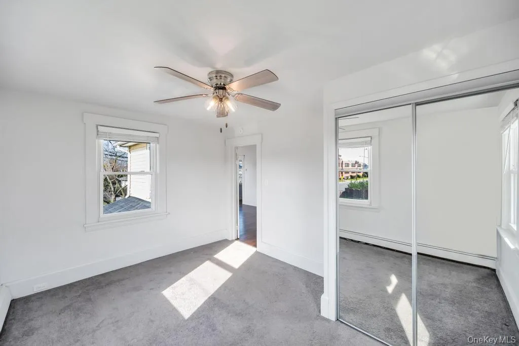 Unfurnished bedroom with a closet, carpet floors, a baseboard heating unit, and ceiling fan Unfurnished bedroom with a closet, carpet floors, a baseboard heating unit, and ceiling fan
