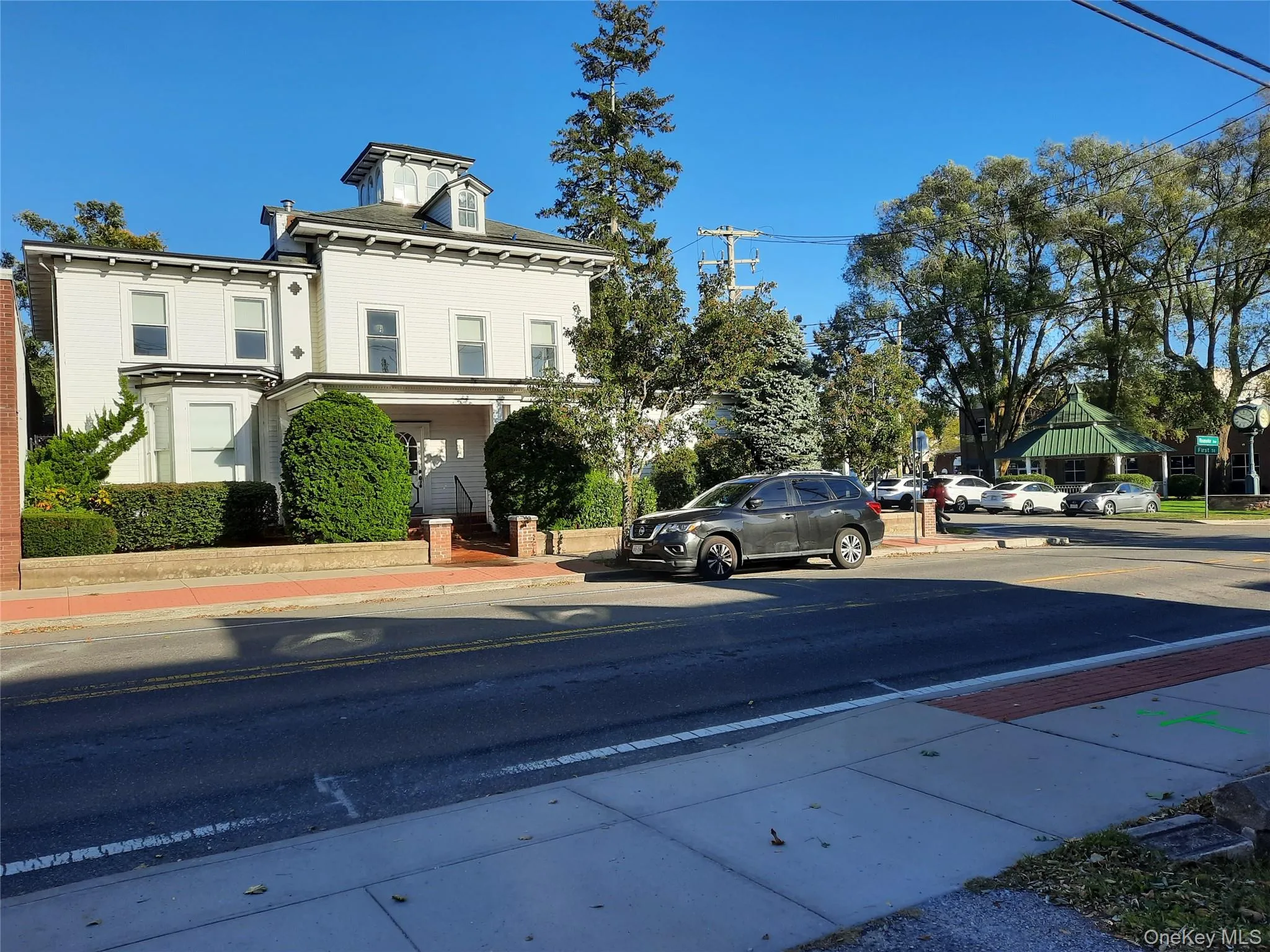 View of asphalt street featuring curbs, sidewalks, and street lights View of asphalt street featuring curbs, sidewalks, and street lights