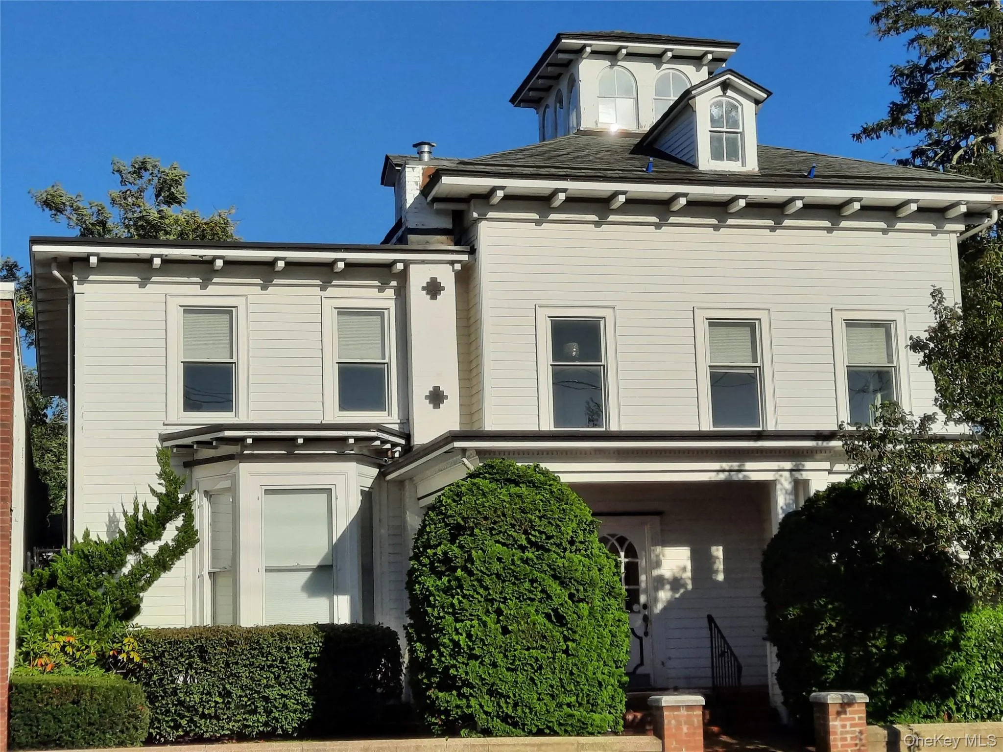 Italianate house with roof with shingles and covered porch Italianate house with roof with shingles and covered porch