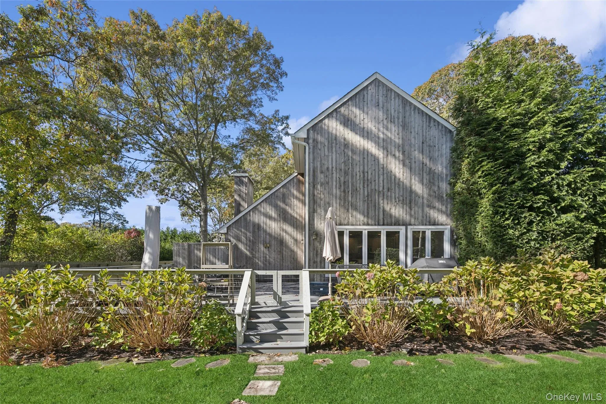 Back of house featuring a large deck and outdoor shower Back of house featuring a large deck and outdoor shower