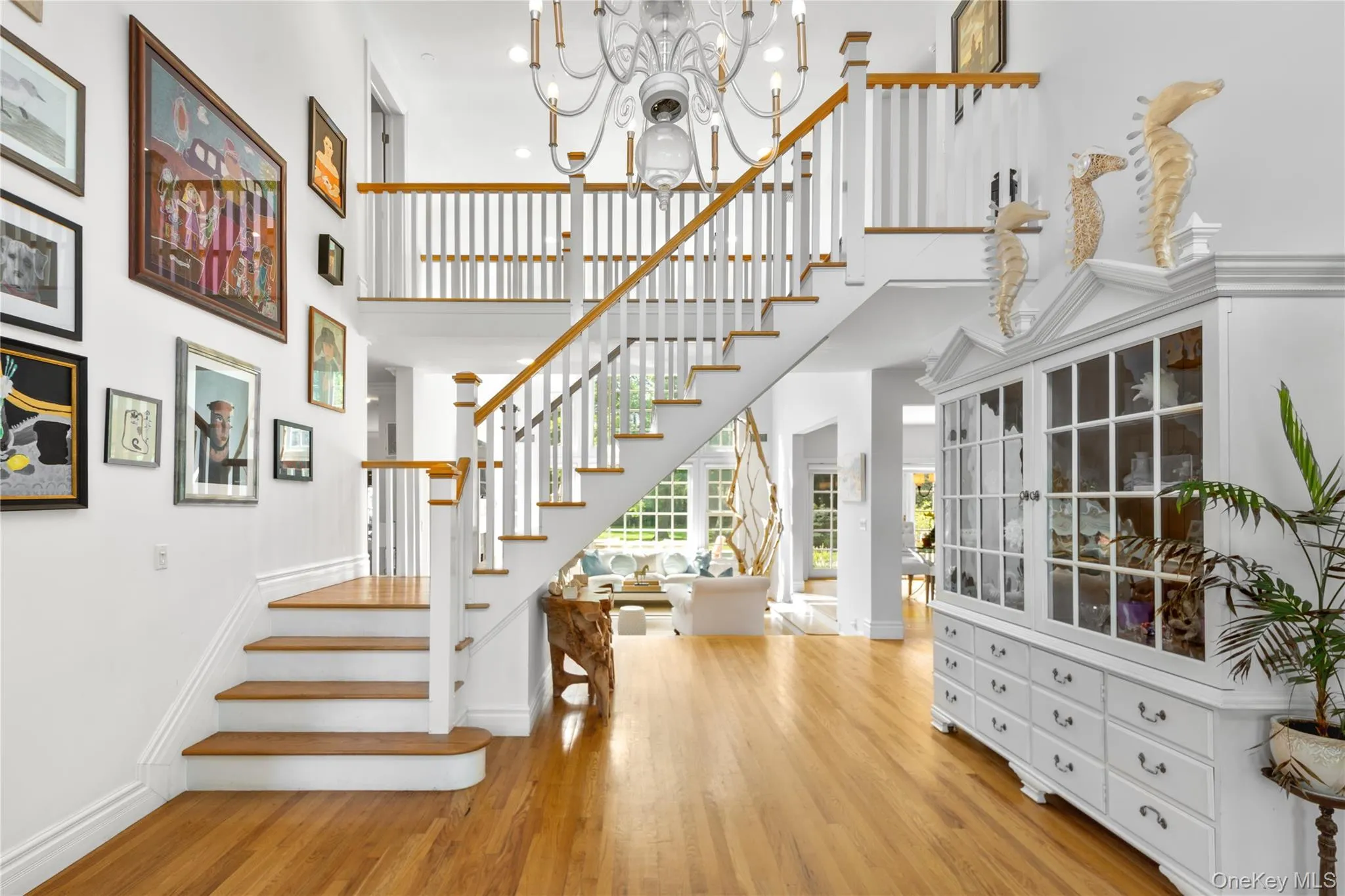 Stairs featuring wood finished floors, a chandelier, and a high ceiling Stairs featuring wood finished floors, a chandelier, and a high ceiling