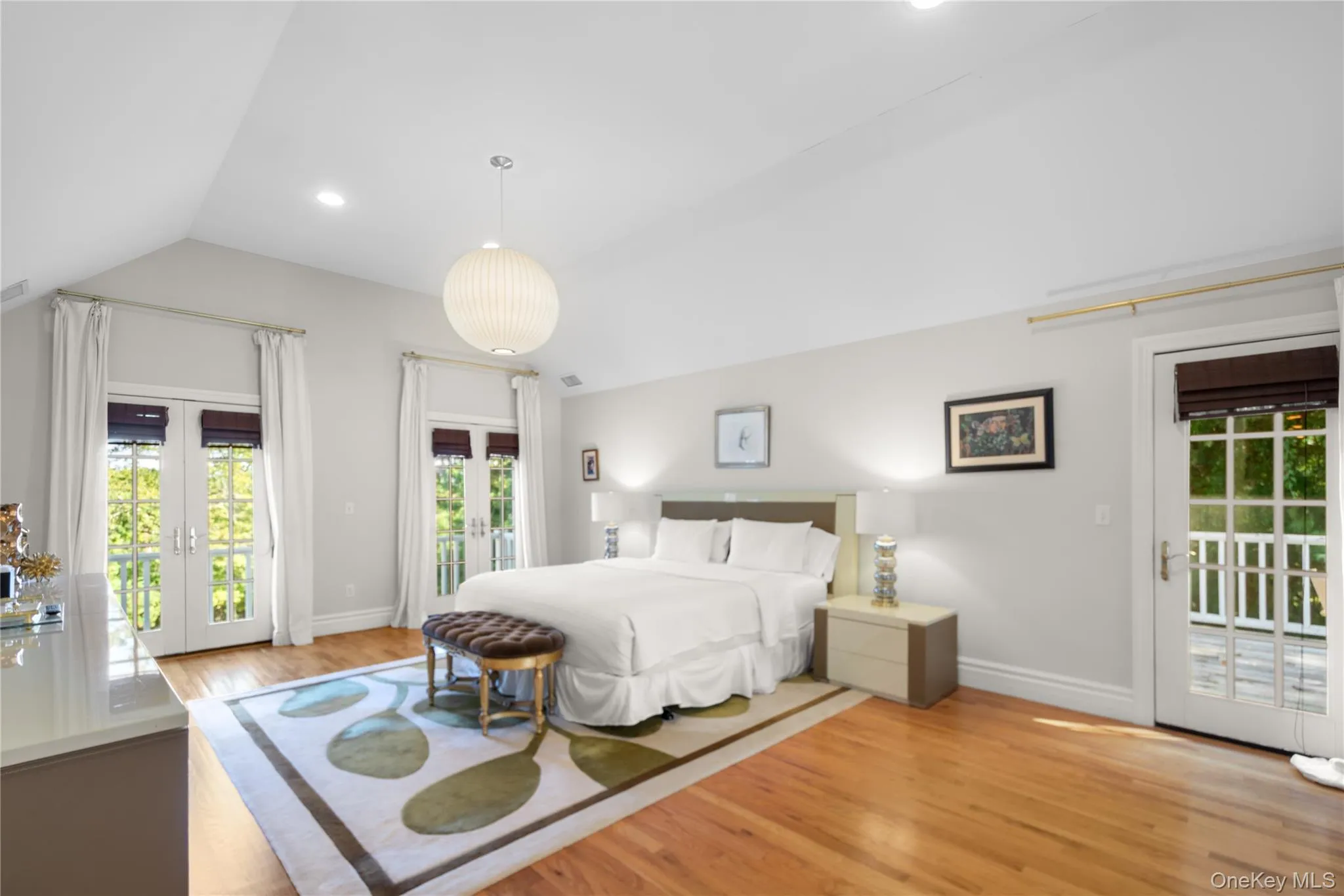 Bedroom with access to exterior, french doors, light wood-style flooring, vaulted ceiling, and recessed lighting Bedroom with access to exterior, french doors, light wood-style flooring, vaulted ceiling, and recessed lighting