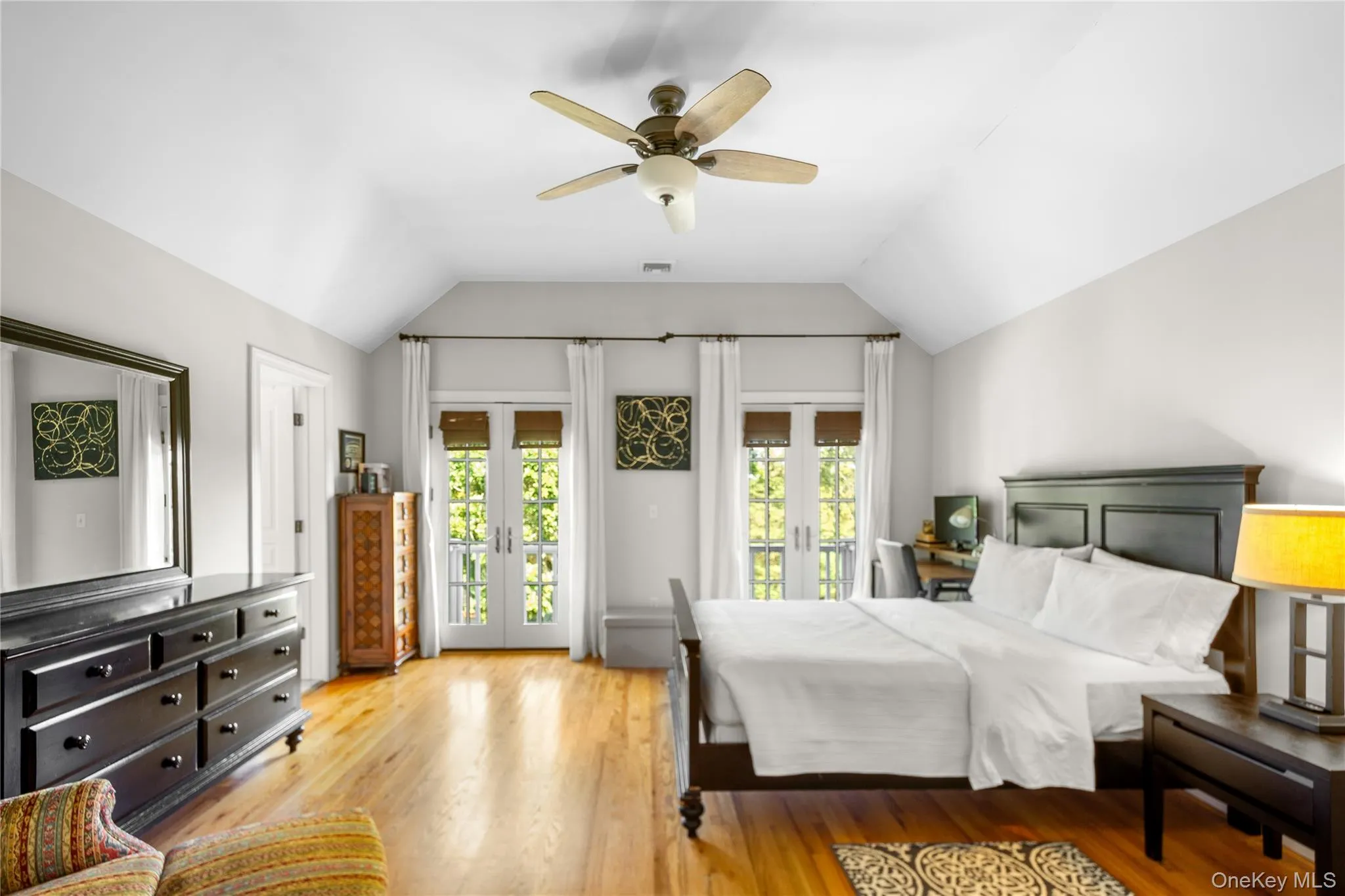 Bedroom with vaulted ceiling, wood finished floors, French doors. Bedroom with vaulted ceiling, wood finished floors, French doors.