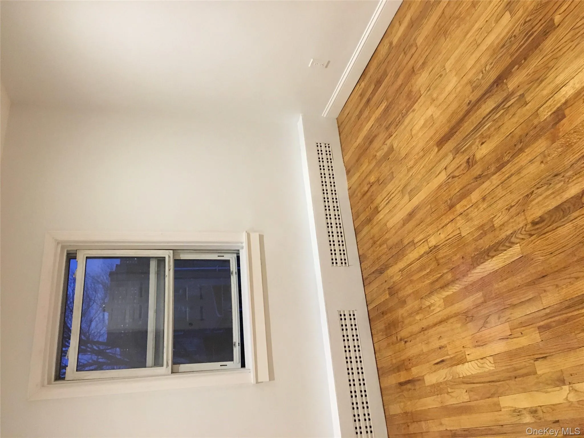 Empty room with light wood-style flooring and baseboard heating Empty room with light wood-style flooring and baseboard heating