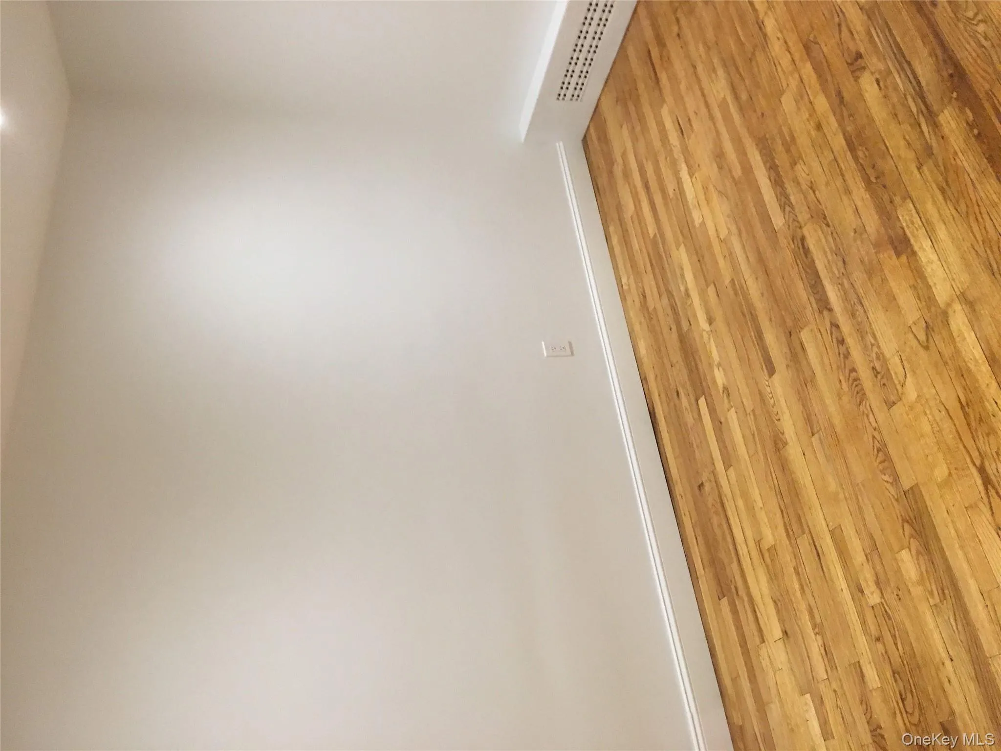 Spare room with light wood-style flooring and baseboards Spare room with light wood-style flooring and baseboards