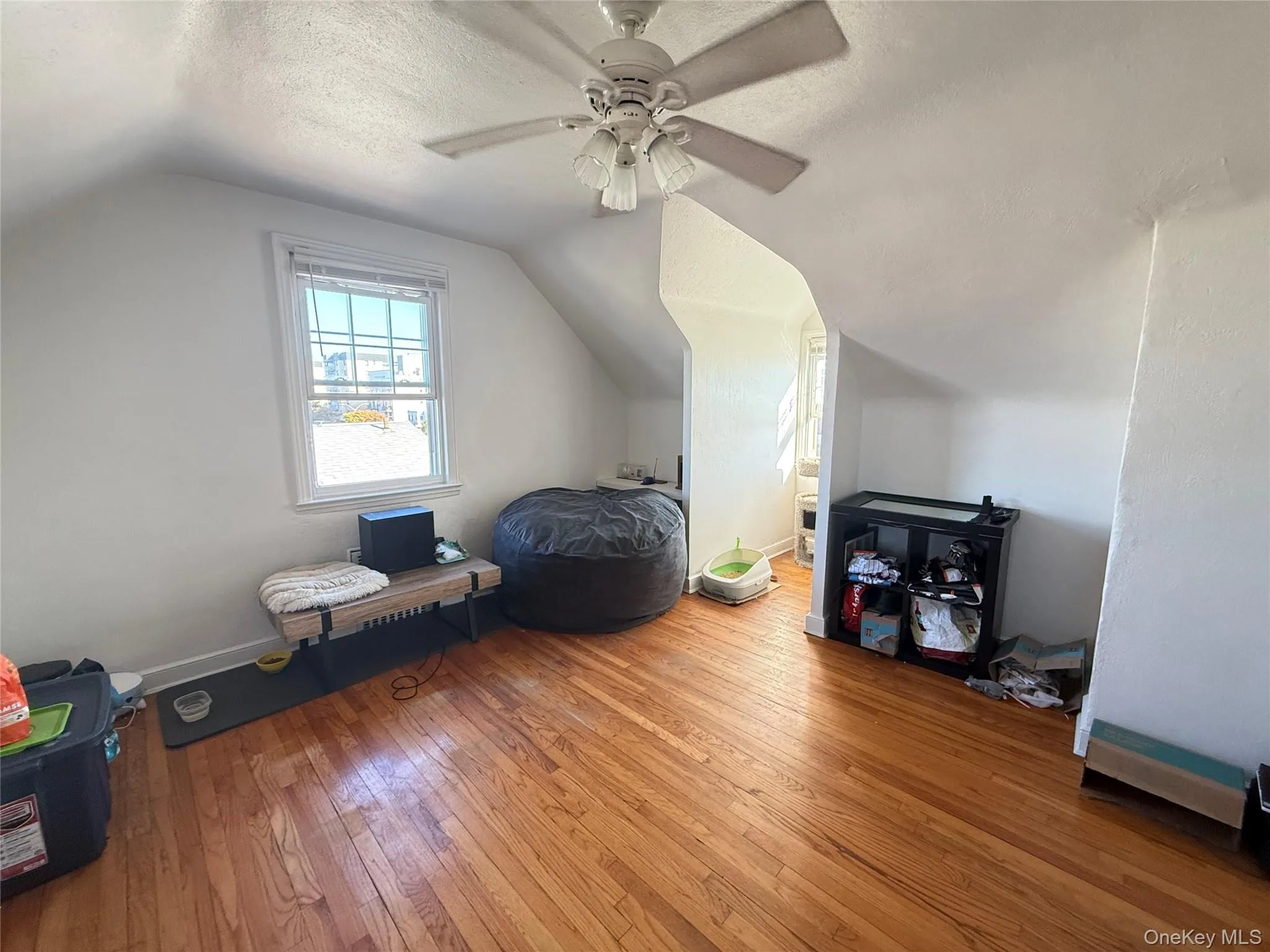 Additional living space with a textured ceiling, lofted ceiling, hardwood / wood-style floors, and ceiling fan Additional living space with a textured ceiling, lofted ceiling, hardwood / wood-style floors, and ceiling fan