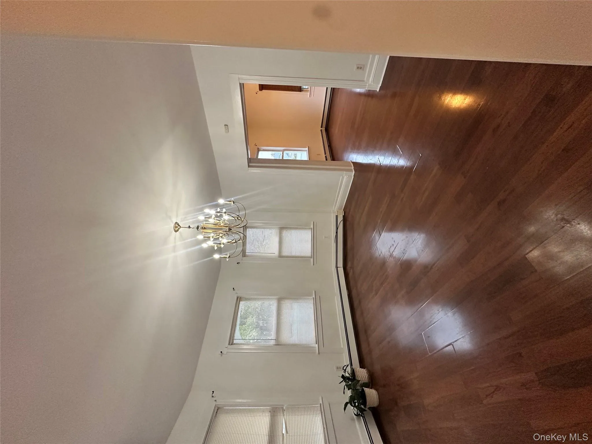 Unfurnished dining area featuring dark wood-style floors, plenty of natural light, a chandelier, and a baseboard radiator Unfurnished dining area featuring dark wood-style floors, plenty of natural light, a chandelier, and a baseboard radiator