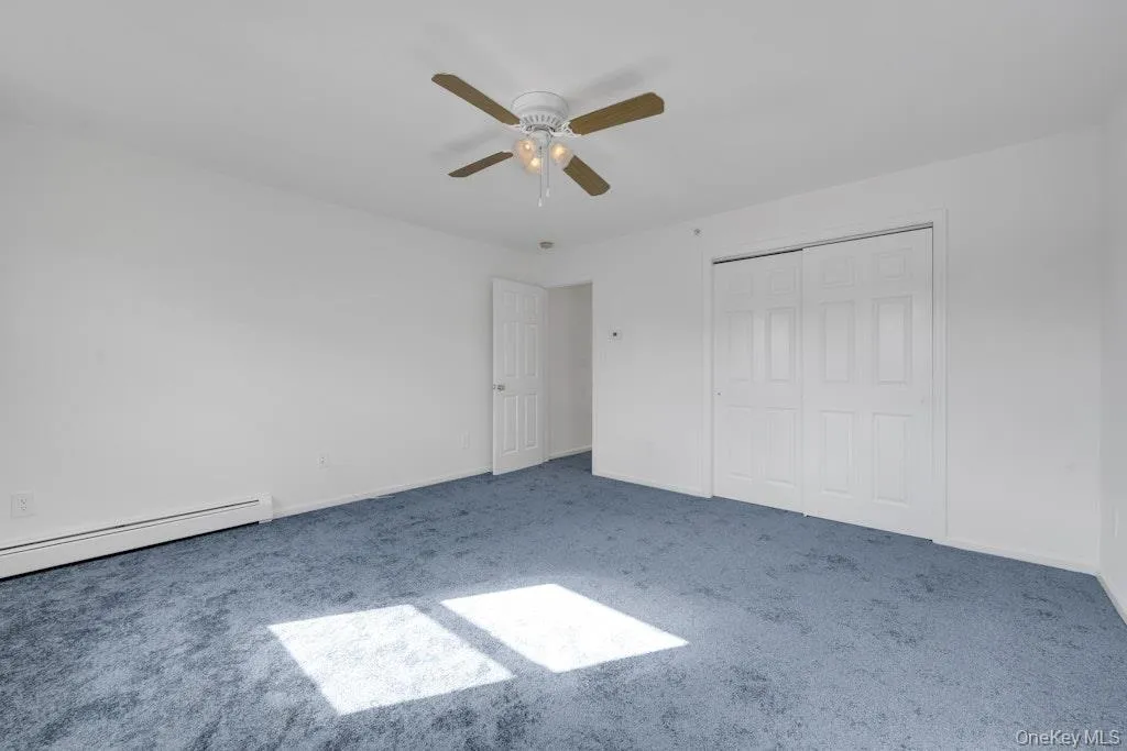 Unfurnished bedroom featuring carpet, a ceiling fan, and a closet Unfurnished bedroom featuring carpet, a ceiling fan, and a closet