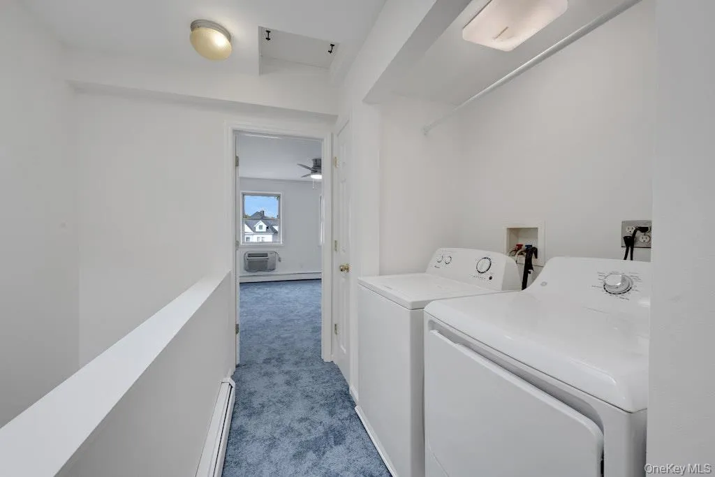 Laundry room with dark colored carpet, a baseboard radiator, and independent washer and dryer Laundry room with dark colored carpet, a baseboard radiator, and independent washer and dryer